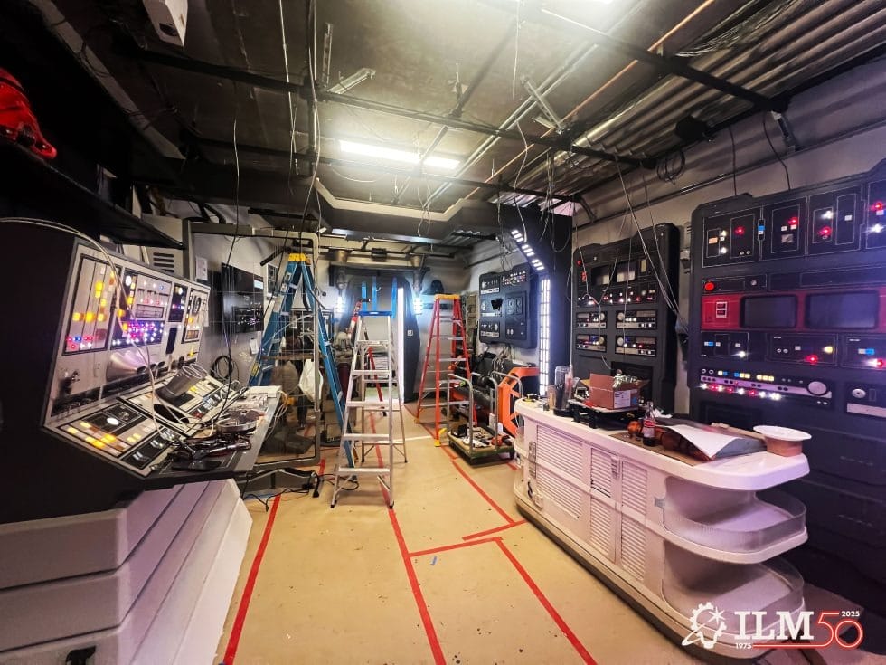 Film set with sci-fi panels, ladders, tools being built, Lucasfilm 50th logo—no Disney castle like those in global Disney parks.