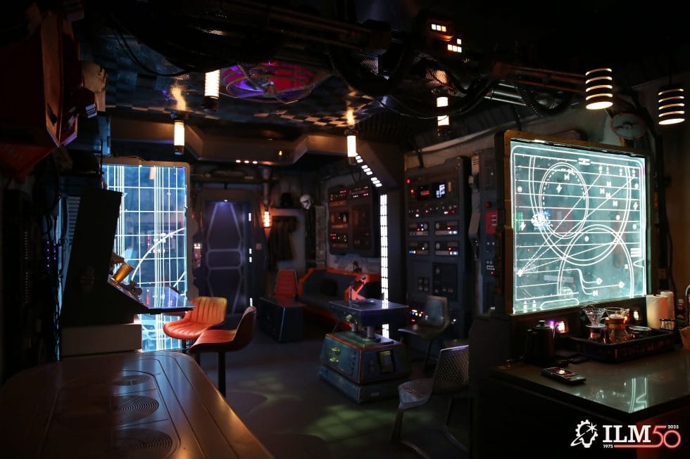 A sleek control room with glowing screens and modern chairs, ILM50 logo and Star Wars details—no Disney castle motifs visible.