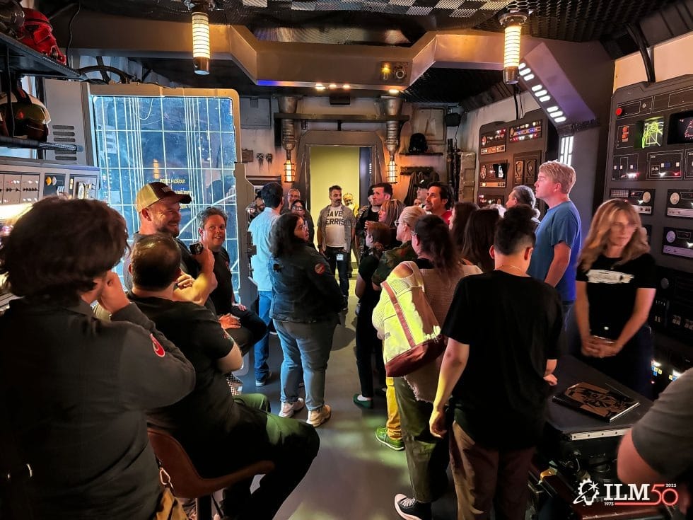 Guests gather in a Star Wars-themed control room at a Disney park, surrounded by glowing panels and screens, evoking galactic travel.