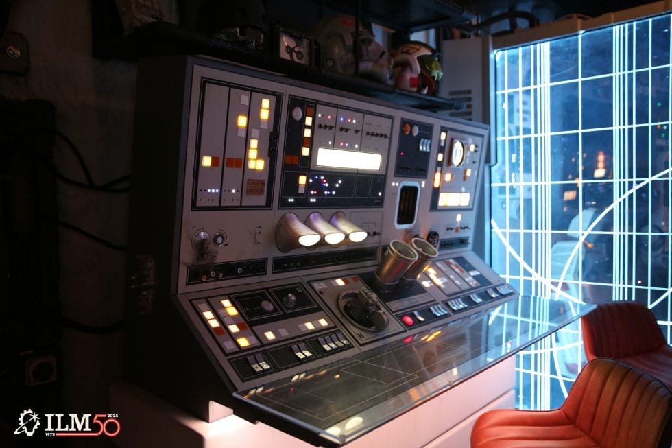 A retro-futuristic Star Wars lounge at Disneyland with a red chair and glowing blue grid screen beside a themed control panel.