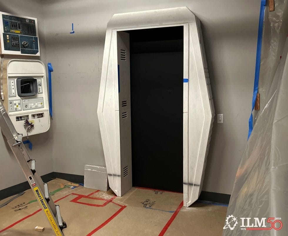 A Star Wars–style sci-fi doorway under construction at a Disney park, with control panels, tools, and tape like in Galaxy’s Edge.