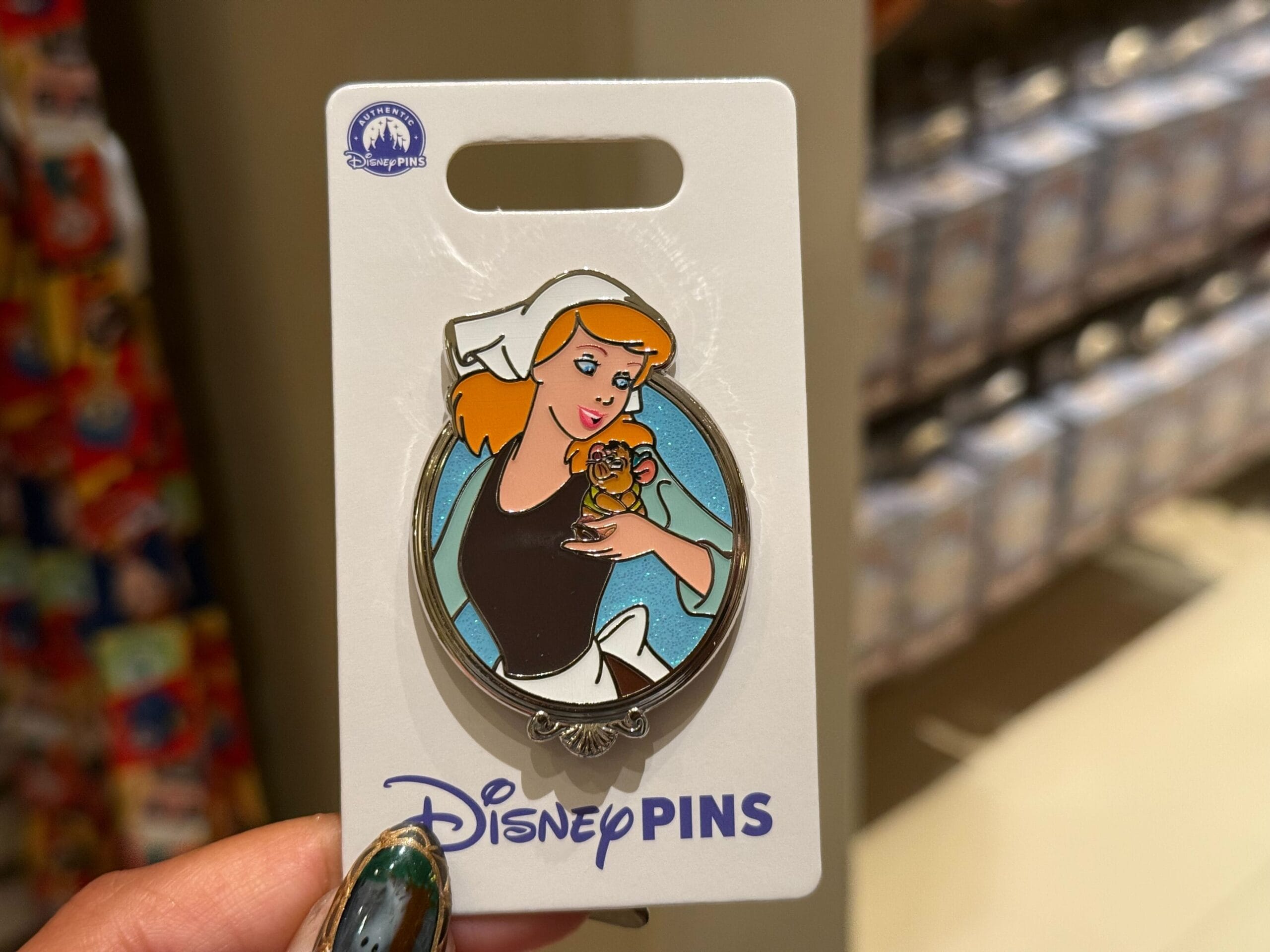 Cinderella in her maid outfit holds a brown mouse on a Disney Parks pin card, resembling classic park merch, no castle shown.