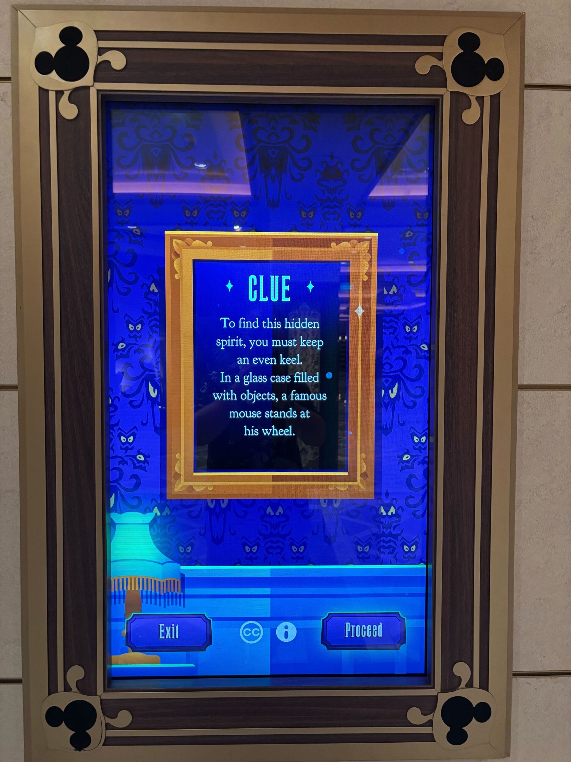 Gold-framed digital screen with a Scavenger Hunt clue for Mickey Mouse; Disney Treasure "Exit" and "Proceed" buttons shown.