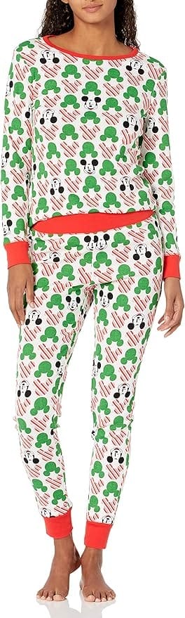 Woman wearing matching pajama set with a pattern of peppermint swirl Mickey heads, solid green Mickey heads and winking Mickey faces.