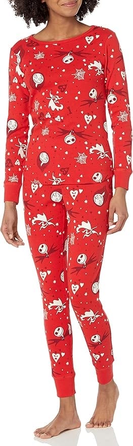 Woman wearing red pajamas with a Nightmare Before Christmas print of Jack Skellington, Sally, Zero, spiderwebs, and hearts.