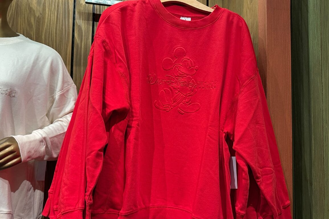 یک سویشرت قرمز با طرح برجسته میکی ماوس و لوگوی «والت دیزنی ورلد»، یادآور سبک نمادین پارک اورلاندو.