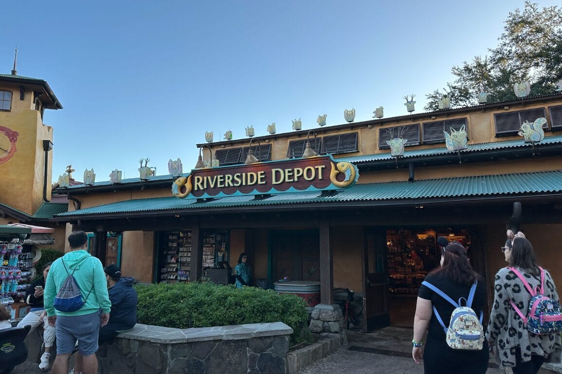 بازدیدکنندگان در حال نزدیک شدن به ریورساید دیپو، فروشگاهی در دیزنی ورلد با مجسمه‌های حیوانات بر روی سقف، زیر آسمانی آفتابی—قلعه‌ای در این نما دیده نمی‌شود.