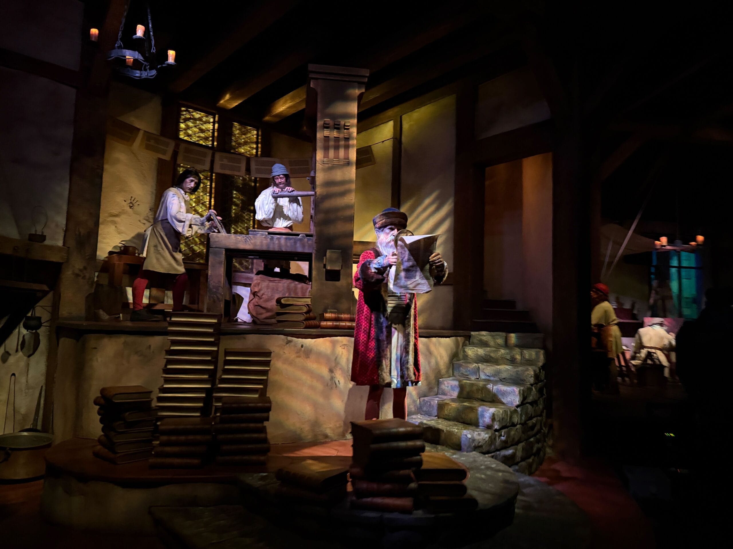 Three animatronic figures in historic dress print books inside Spaceship Earth, just reopened at EPCOT—not a Disney castle scene.