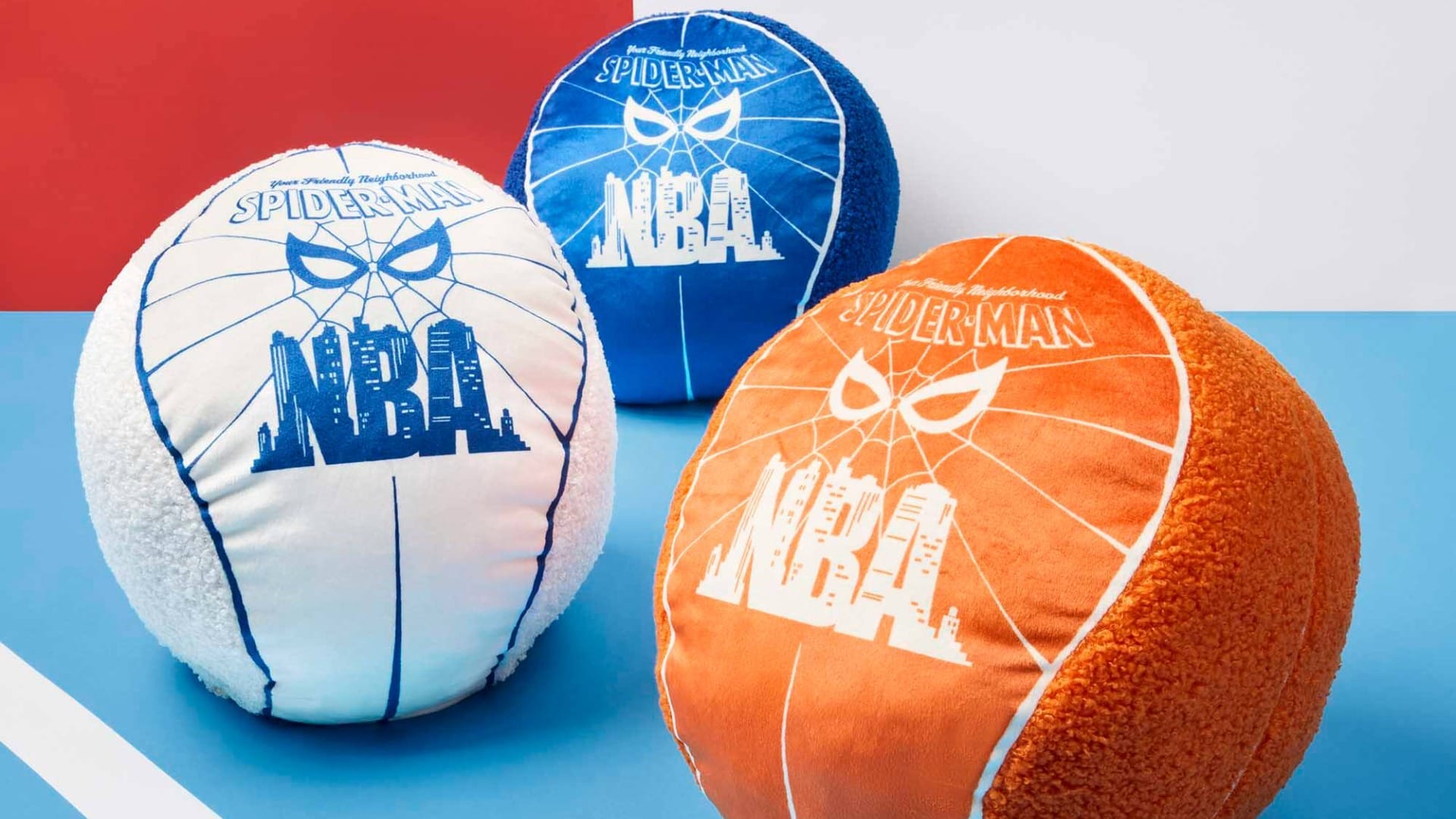 Three plush NBA and Spider-Man basketballs from the Macy's Collection rest on a vibrant court, not far from any Disney castle.