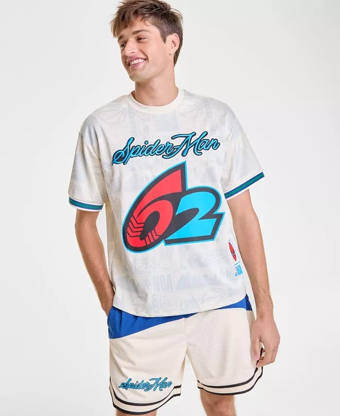 A man smiles in a white "Spider-Man 62" t-shirt from Macy's and blue-accent basketball shorts, looking ready for Disney parks fun.