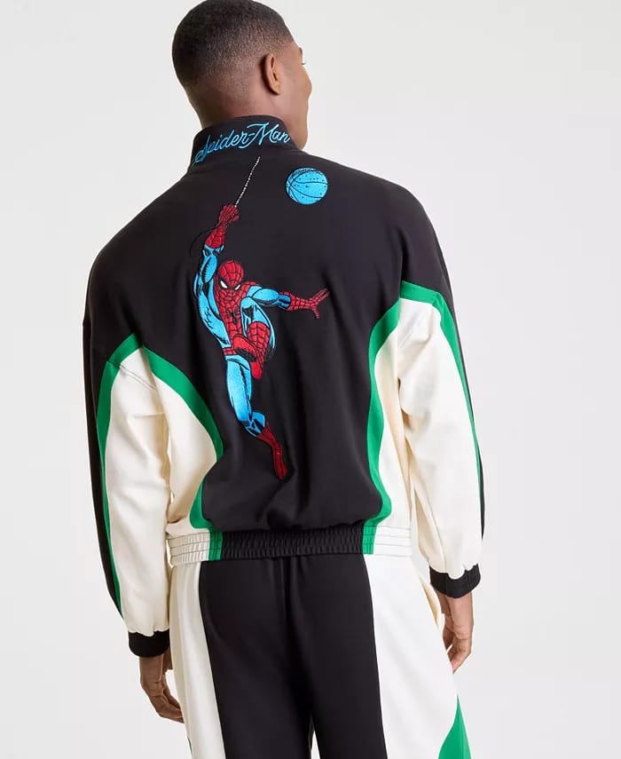 A person at a Disney park sports a black, green, and white Macy's Collection jacket featuring a bold Spider-Man graphic on the back.