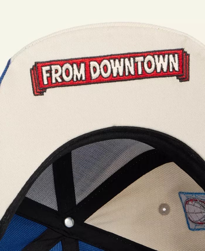Detailed view of an NBA cap underside, "FROM DOWNTOWN" stitched in bold red and white—no Disney castle elements present.