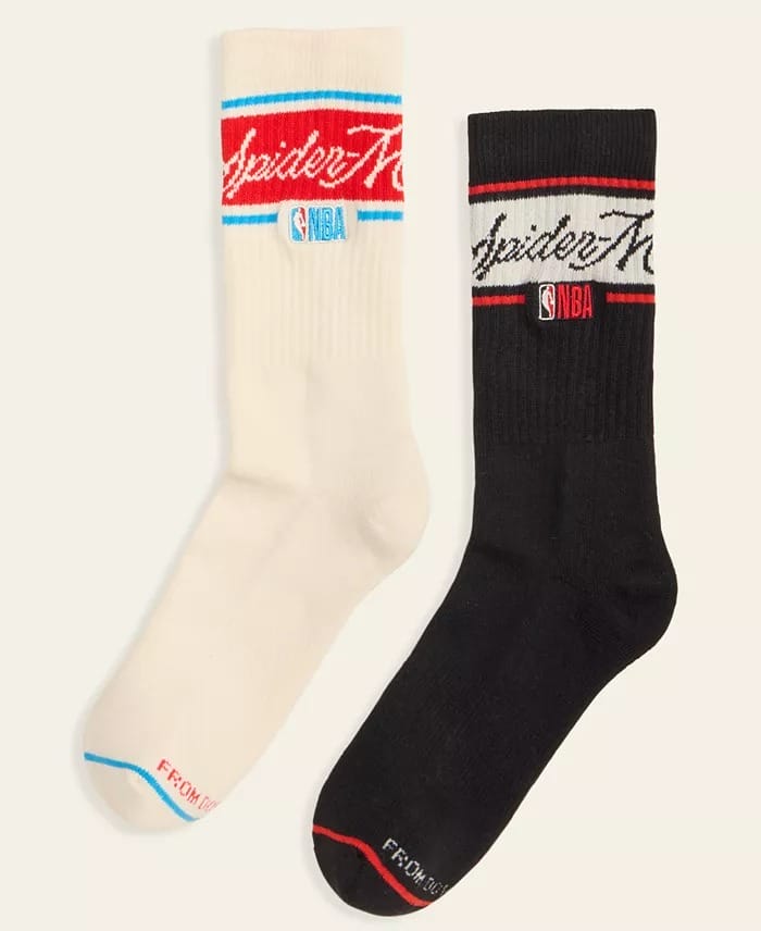 A pair of crew socks from Macy's, one white and one black, featuring Spider-Man and NBA logos near the top—no Disneyland castle.