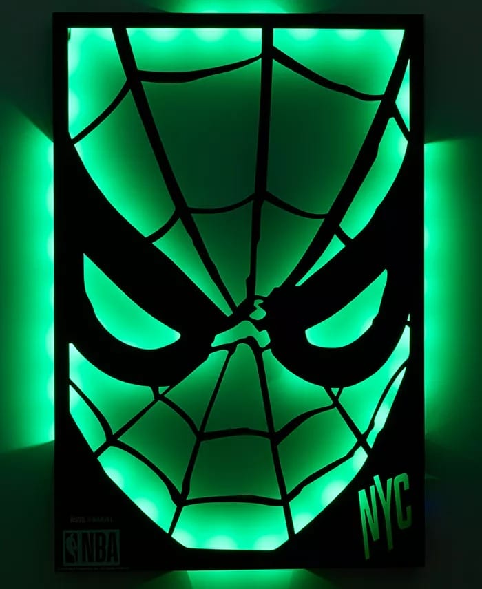 Green neon Spider-Man face sign, NYC & NBA logos—NBA x Spider-Man Macy's Collection. No castle like those at Disney Parks shown.