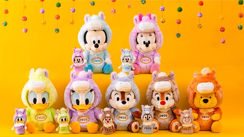 Plush Disney park characters in bright animal onesies sit in rows on yellow, evoking park displays with festive decorations overhead.