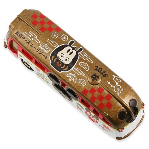 Gold and red toy bus with cartoon monkey, checkerboard accents, "2026" on top; Tokyo Disney Resort New Year's item—no castle pictured.