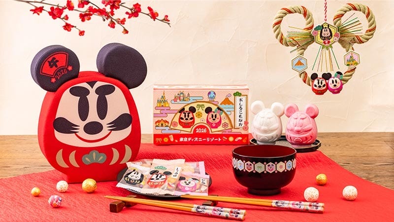 Disney park-inspired Japanese New Year treats and decor on a red mat with festive packaging, reminiscent of Tokyo Disneyland flair.