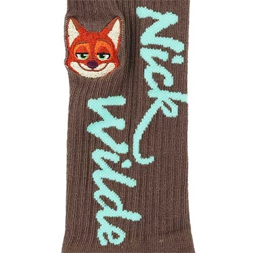 Brown sock with "Nick Wilde" in blue and an embroidered fox face, a fun Zootopia 2 find from a Disney Park—no castle in sight.
