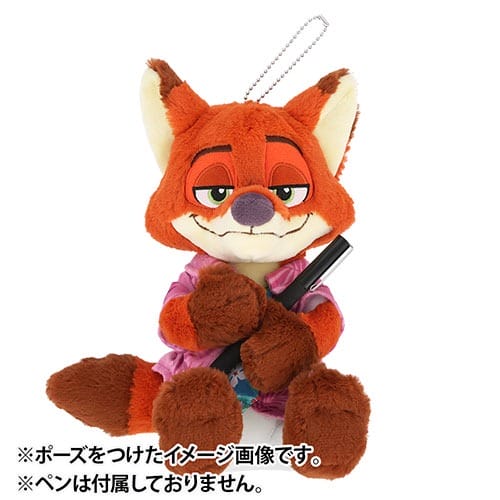 Plush fox toy in pink shirt holding a pen, from Tokyo Disneyland Zootopia 2 merch, Japanese text beneath—no castle pictured here.
