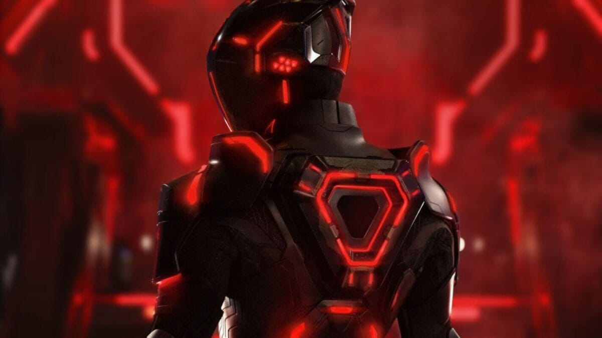 A person in a Tron: Ares-inspired armored suit stands with their back turned in a glowing red-lit scene, echoing Disney's futuristic park rides.