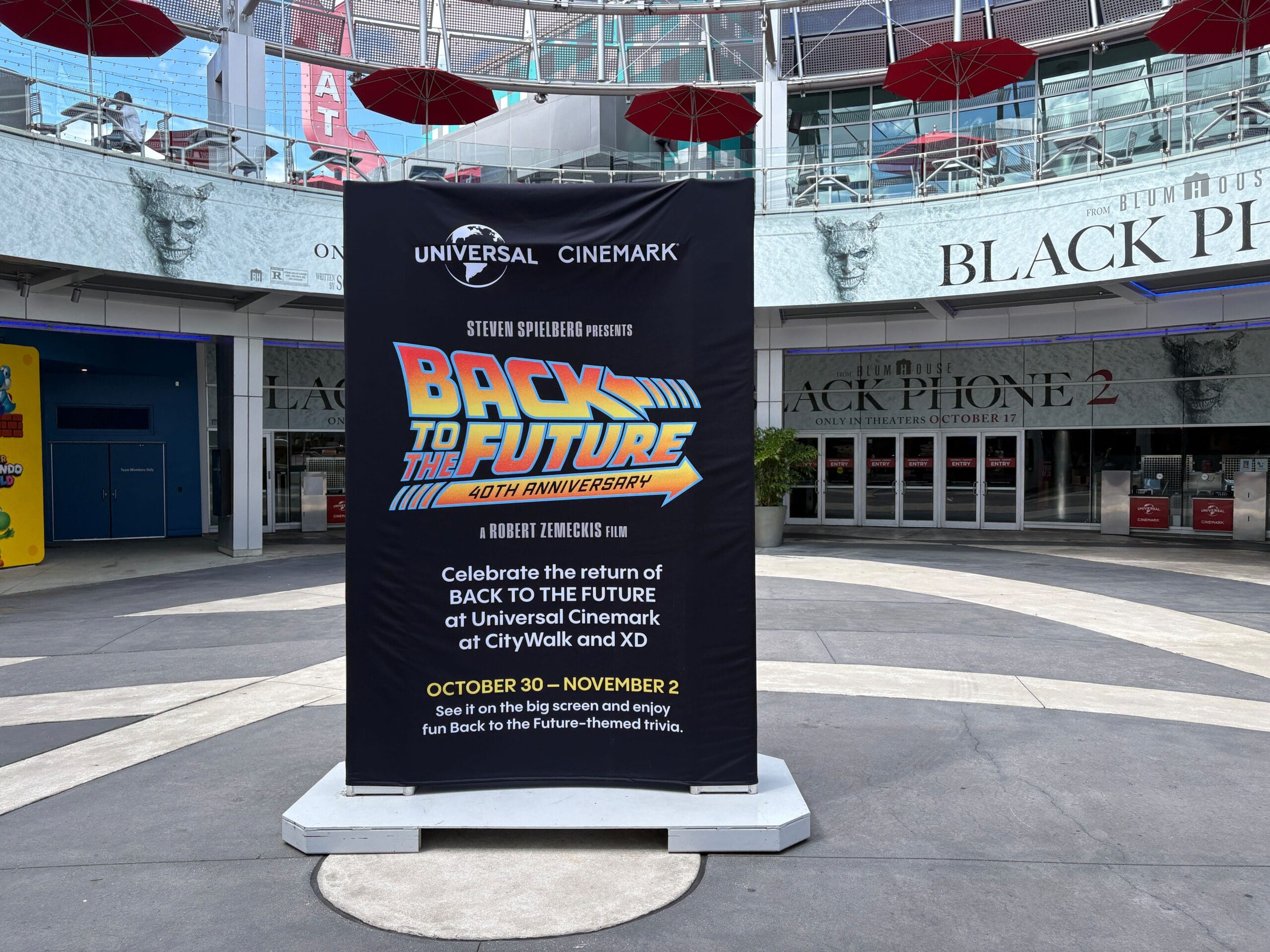 A sign at Universal Cinemark, CityWalk, advertises "Back to the Future 40th Anniversary" with event dates, not a Disney castle.