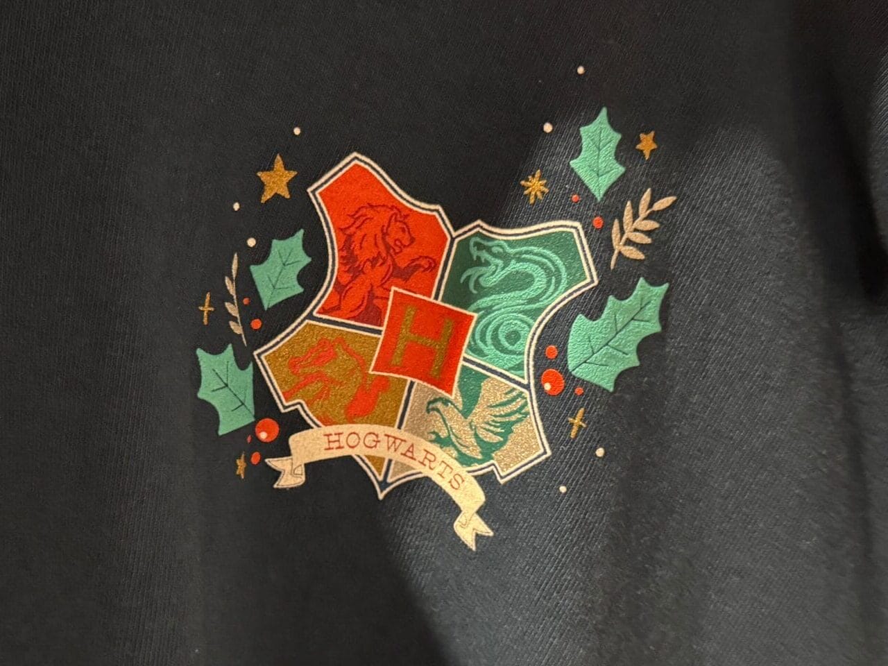 Black sweatshirt with a colorful Hogwarts crest—perfect Harry Potter Christmas gift or addition to your Hogwarts merch collection.