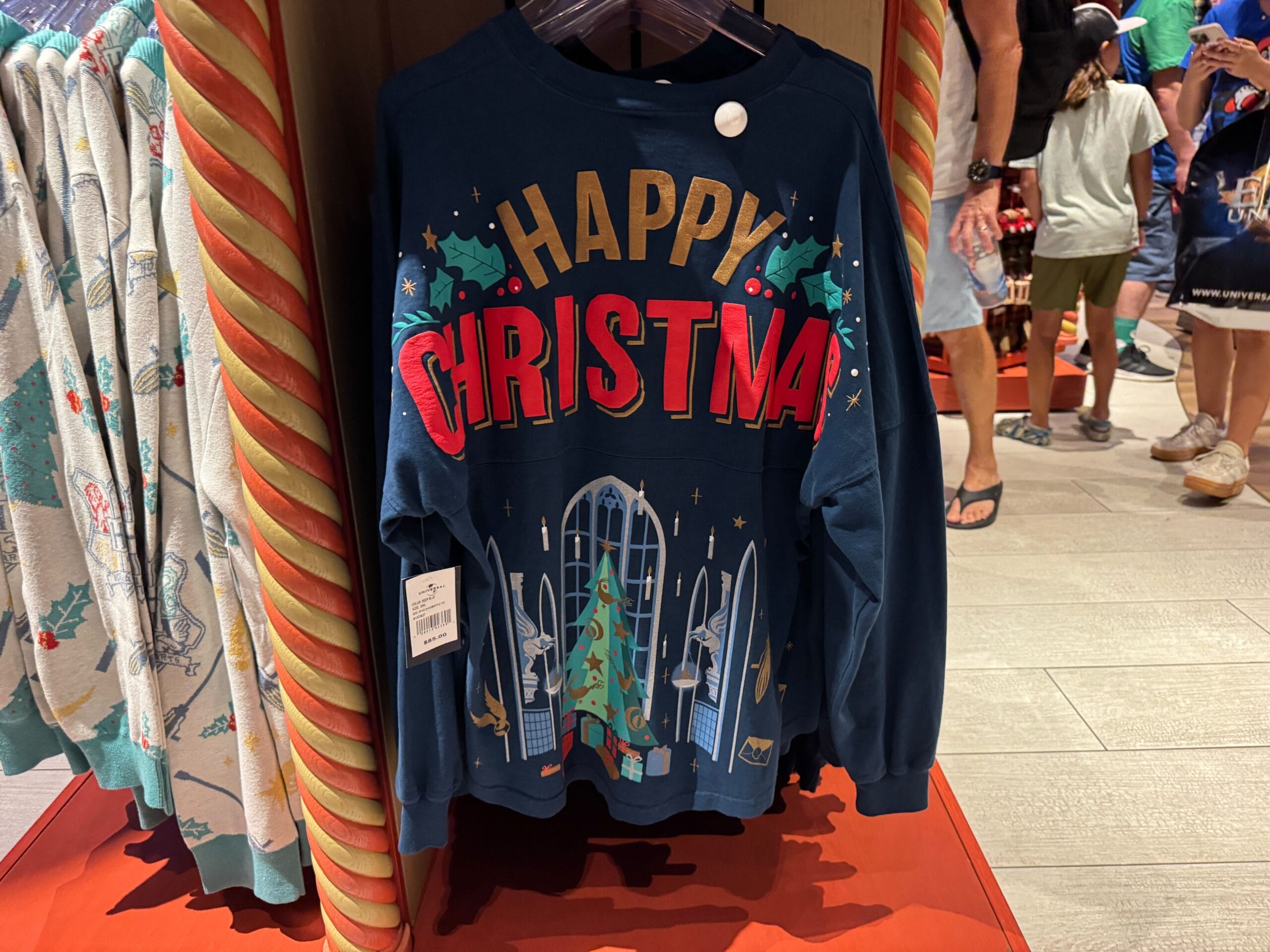 A navy blue sweatshirt with “Happy Christmas” and festive graphics, perfect for Harry Potter Christmas fans.