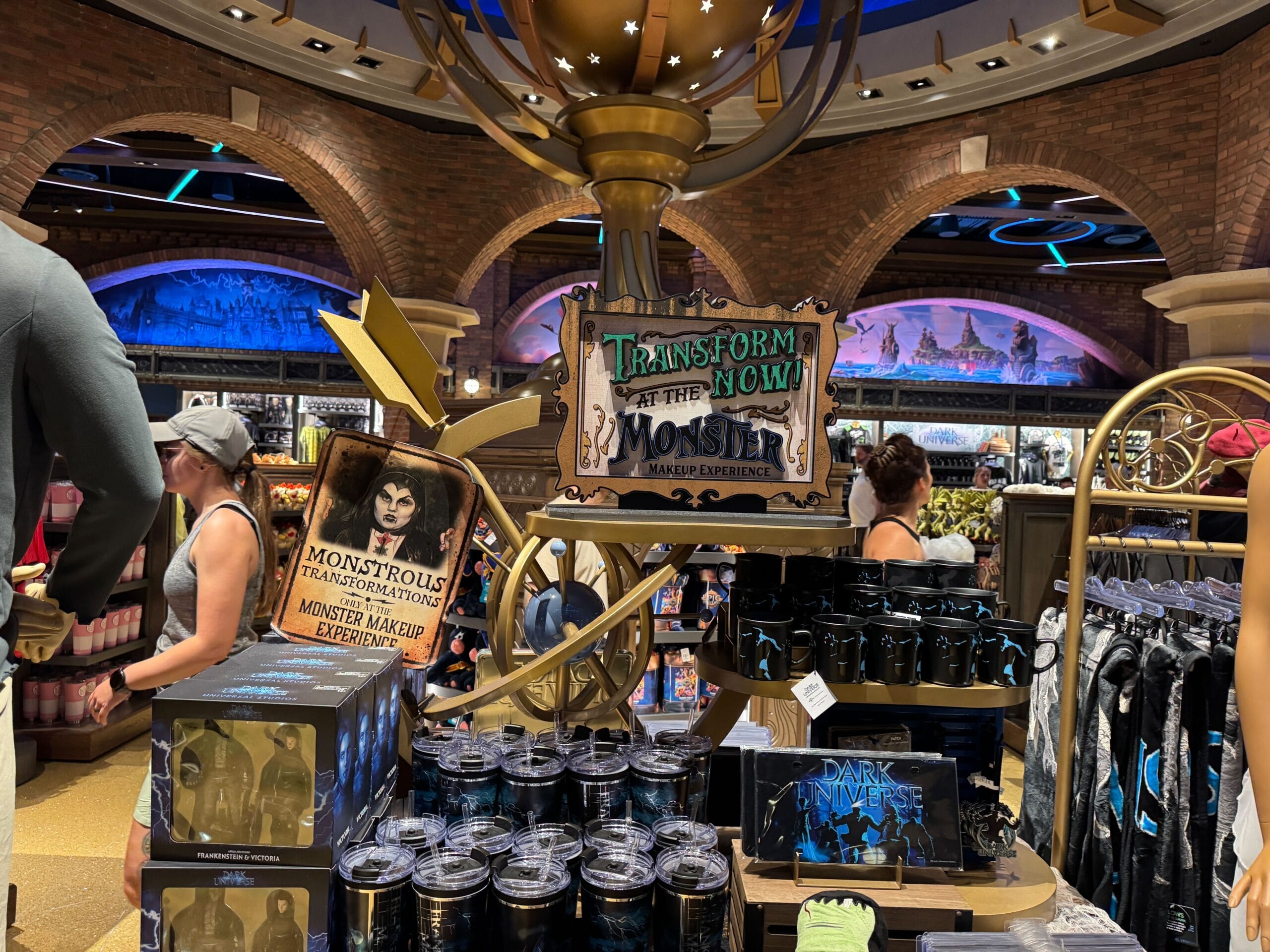 A store display with Epic Universe signage advertising a Monster Makeup Experience and monster-themed merchandise.