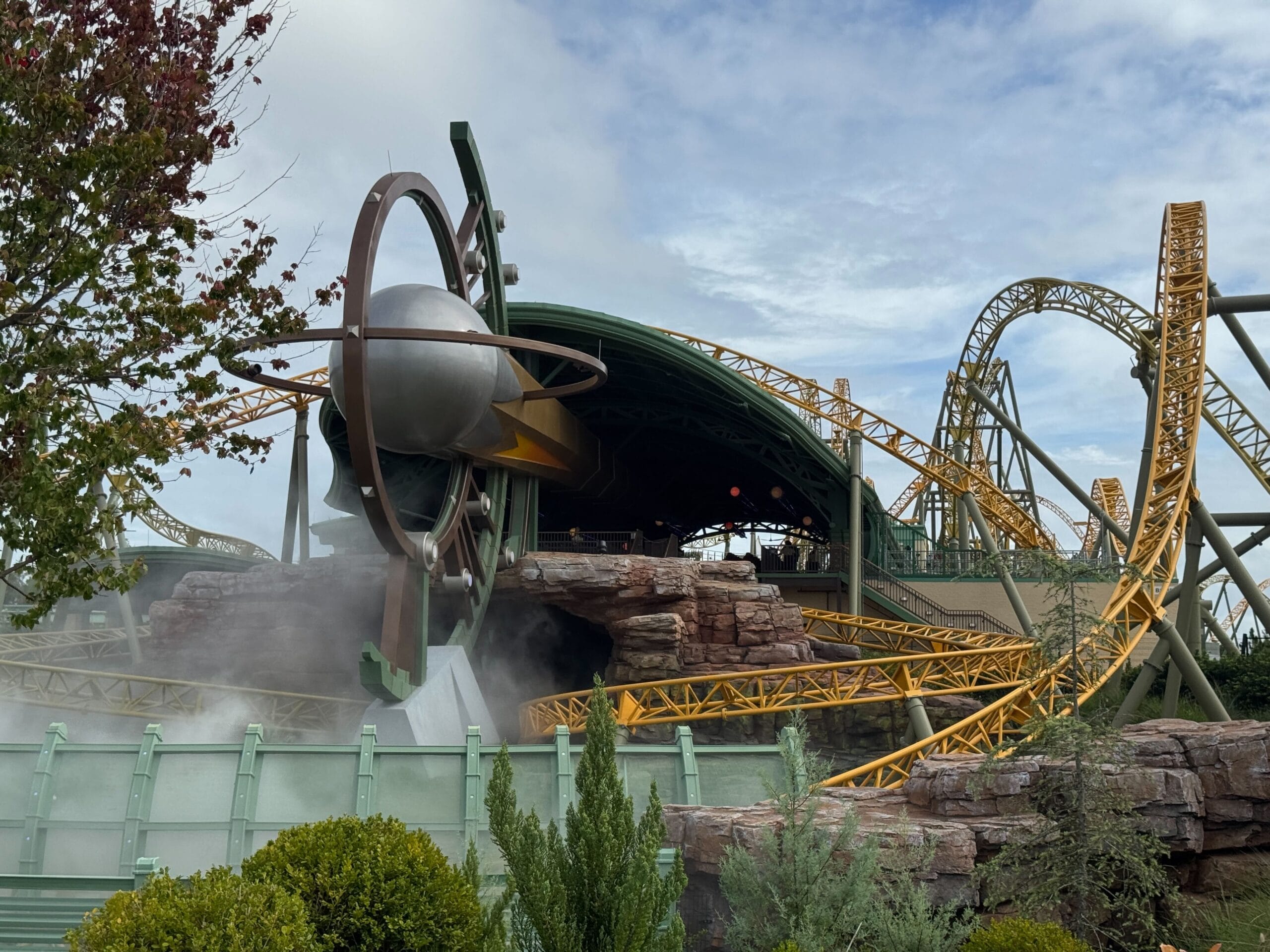 Stardust Racers, a steel roller coaster with yellow tracks, is testing for reopening under a cloudy sci-fi themed sky.