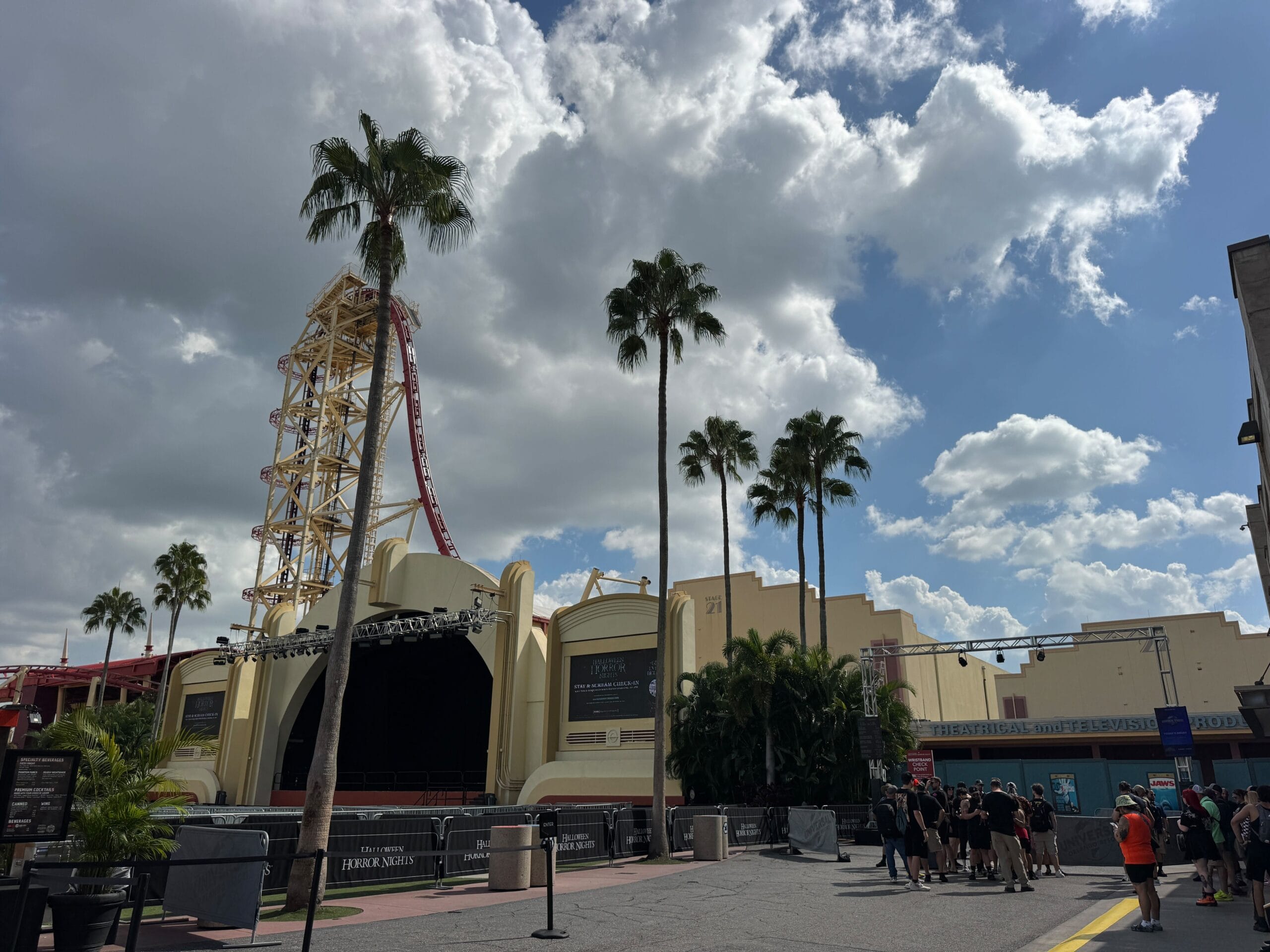 People gather near the Hollywood Rip Ride Rockit stage, surrounded by palms at Universal Studios Florida.