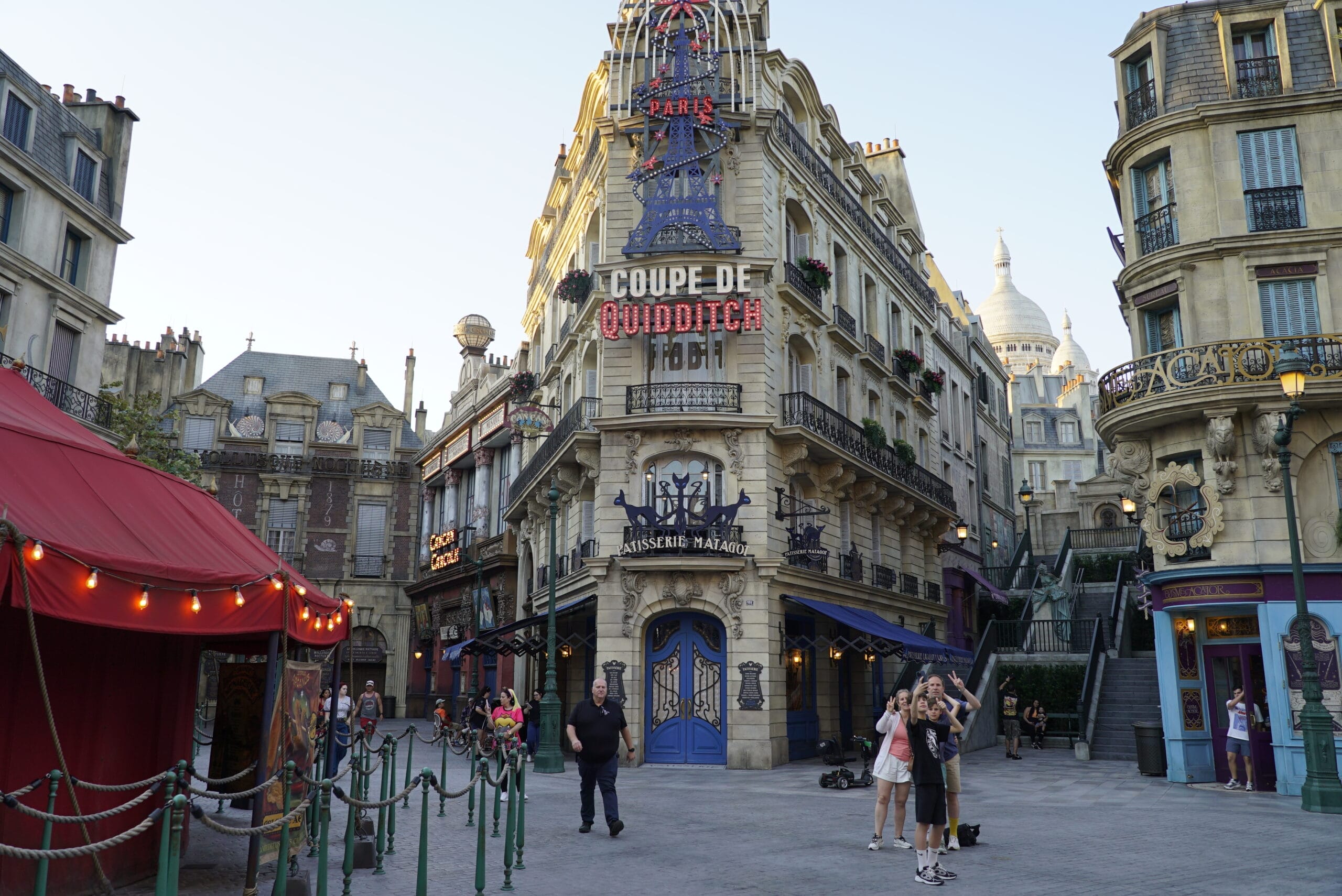 Guests stroll through the 1920s Parisian setting of The Wizarding World of Harry Potter – Ministry of Magic at Epic Universe.