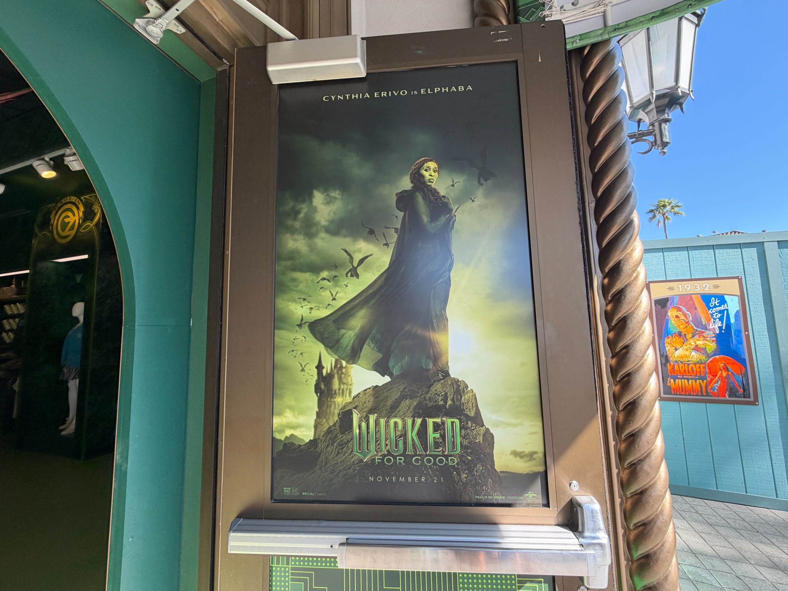 Wicked posters show Cynthia Erivo as Elphaba, boldly posed with flying monkeys in vibrant costumes, evoking Disney park magic.
