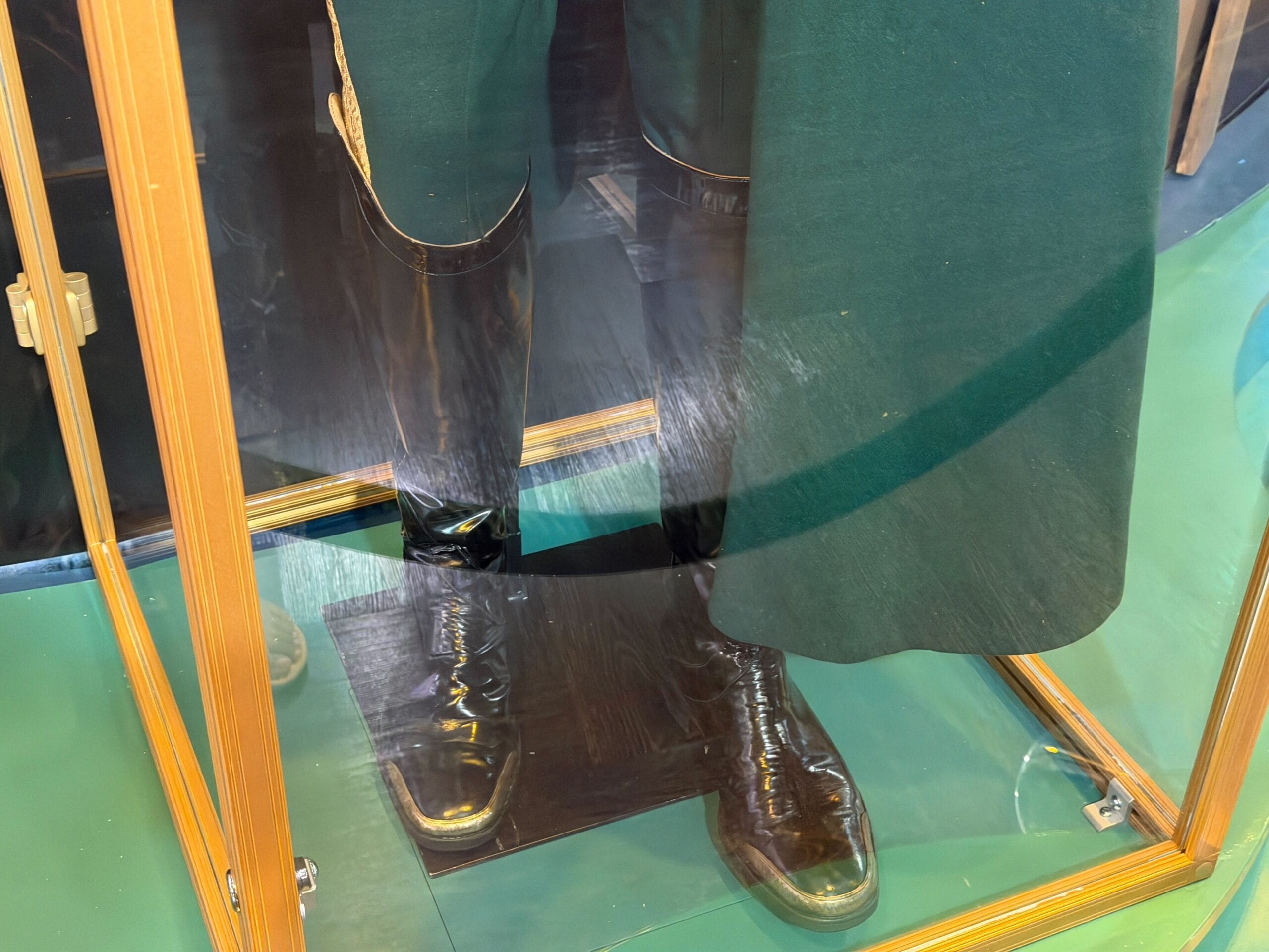 Shiny black boots on display at Universal Studios Florida, paired with a green Wicked costume—no Disney castle like Cinderella’s in view.