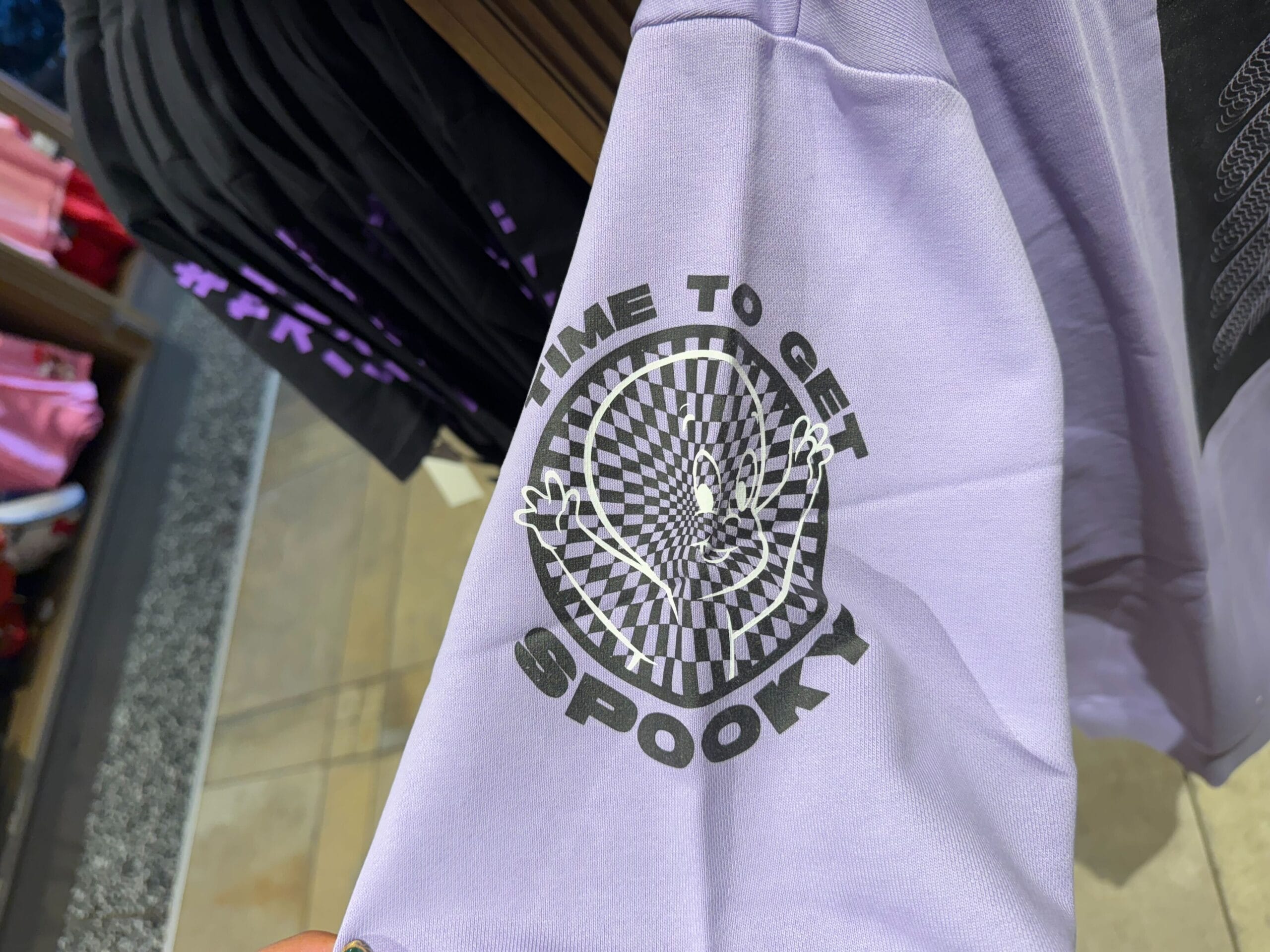 A lavender Casper Apparel sleeve with a ghost and "TIME TO GET SPOOKY" text above a spiral, echoing whimsical Disney park vibes.