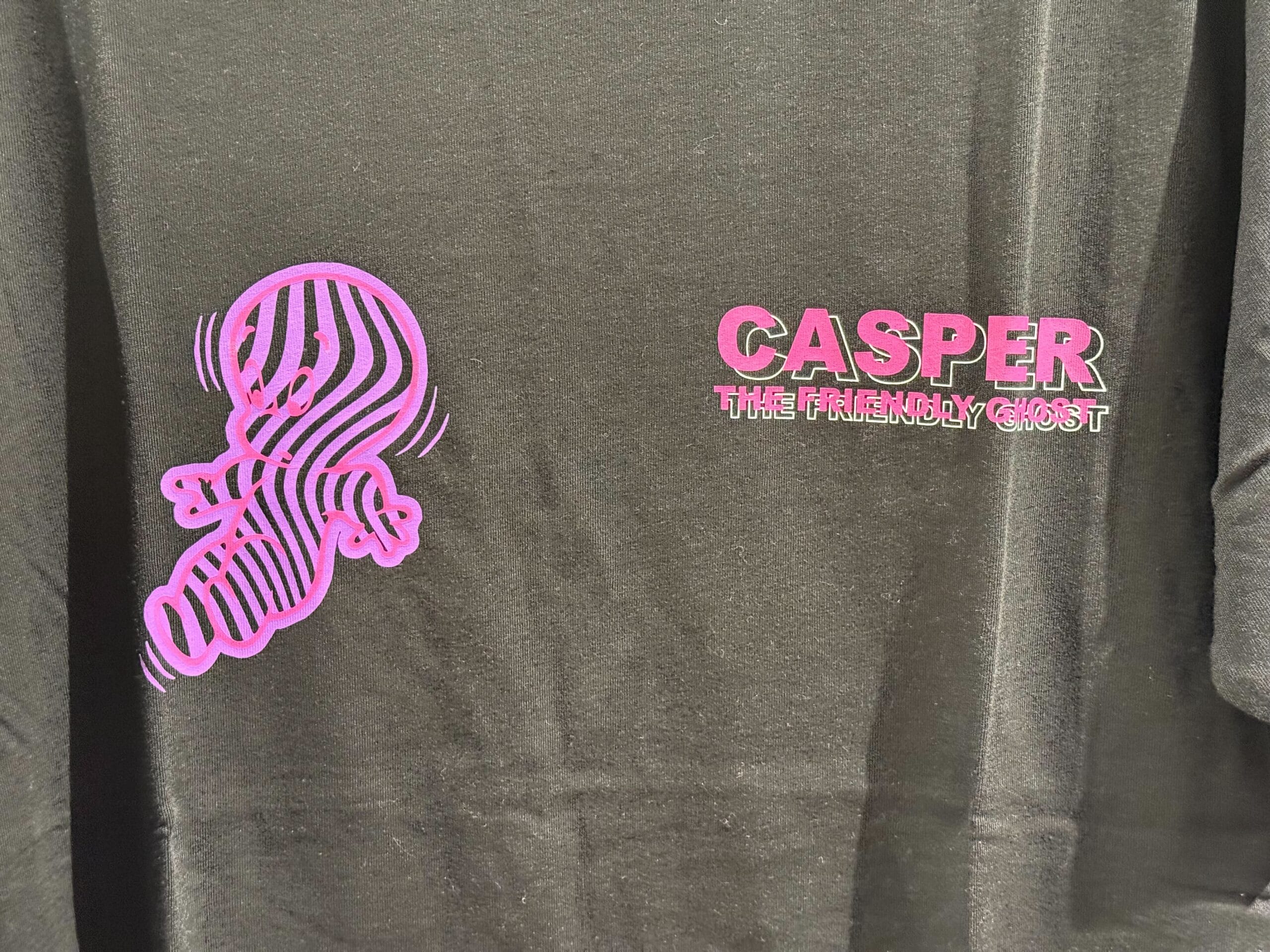 Black shirt from Casper Apparel featuring a pink Casper the Friendly Ghost, Universal Studios—no Disney castle like at Disneyland parks.