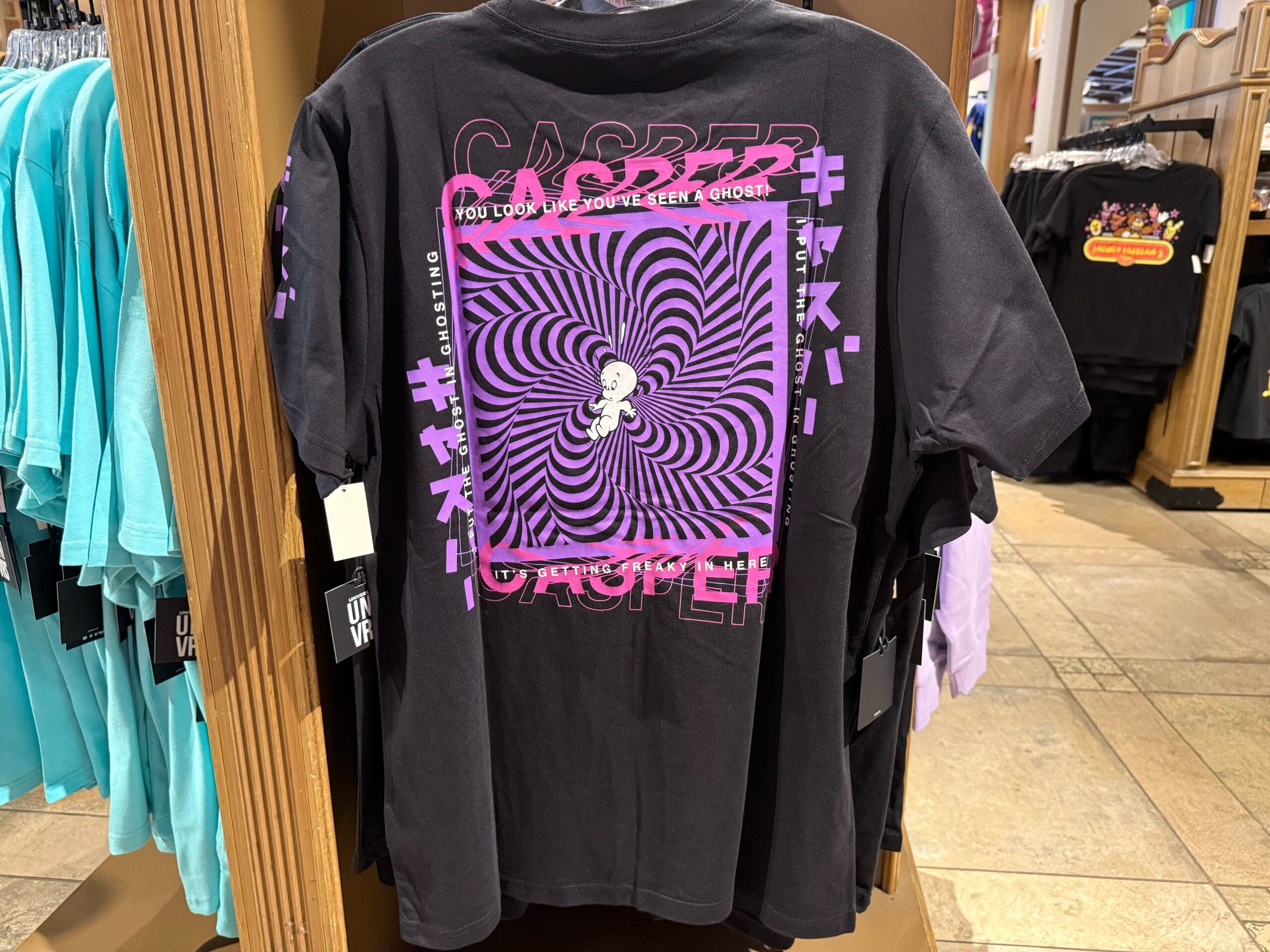 Black Casper Apparel t-shirt with a purple hypnotic spiral, displayed at Universal Studios Hollywood, not a Disney Parks castle tee.