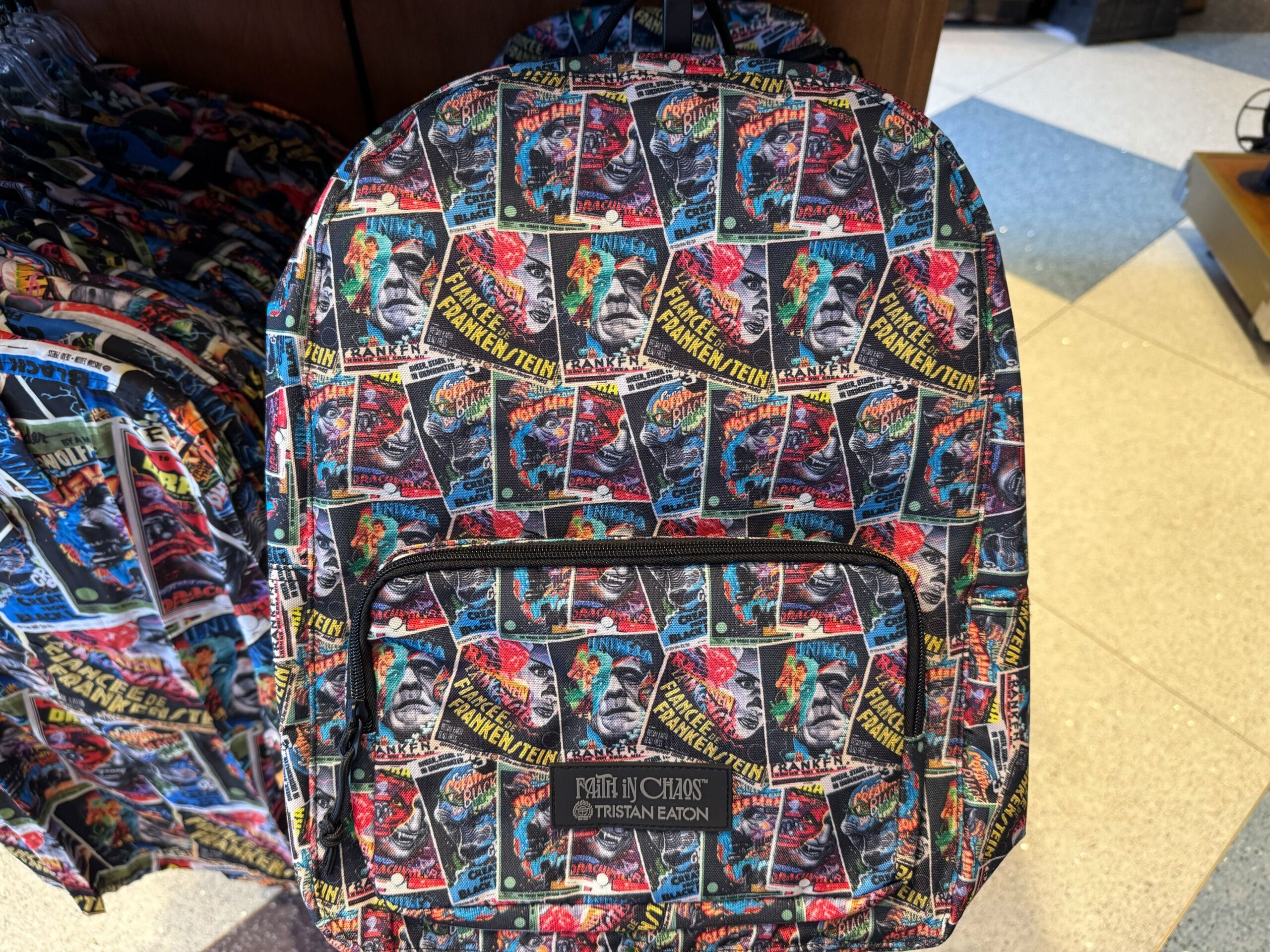 Backpack with a vibrant collage of vintage Frankenstein comic covers, reminiscent of bold merchandise found in Disney Parks shops.