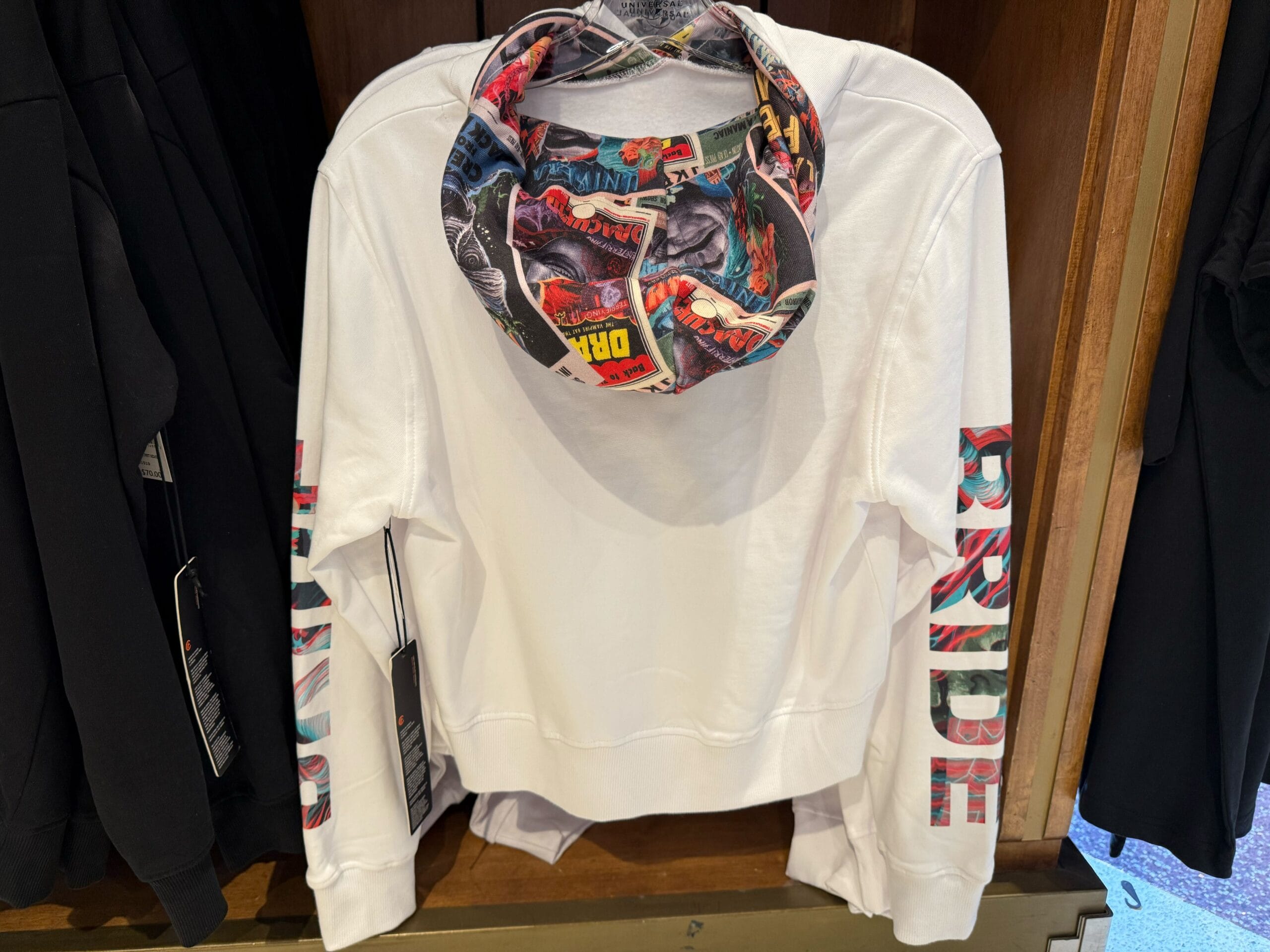 White Marvel sweatshirt with comic-print hood and sleeves, featuring Universal Studios style, not seen at Disney Parks' castle shops.