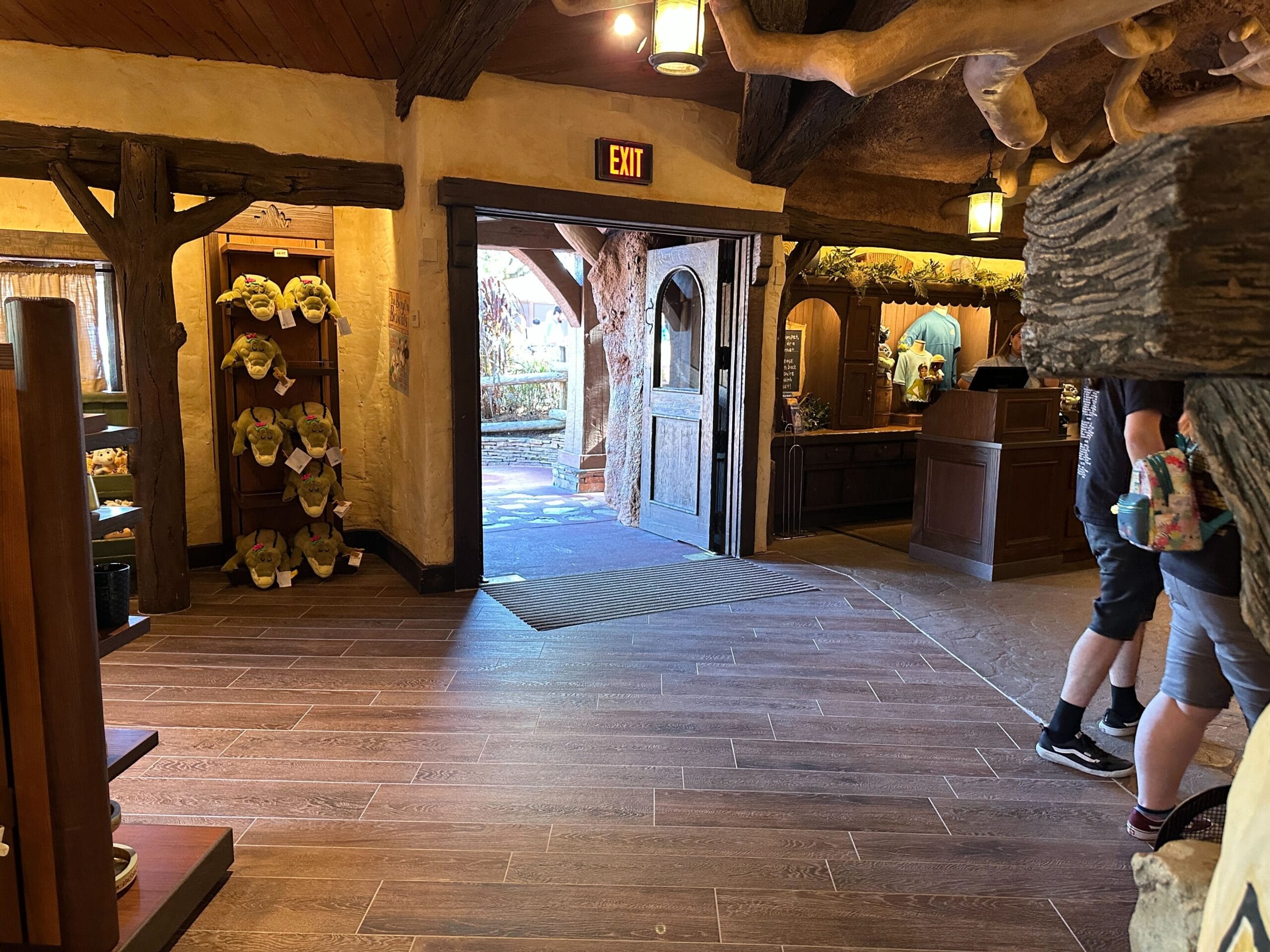 A cozy Critter Co-op shop interior with wood beams, open door, and plush toys—reminiscent of Disneyland’s Grizzly Peak style.