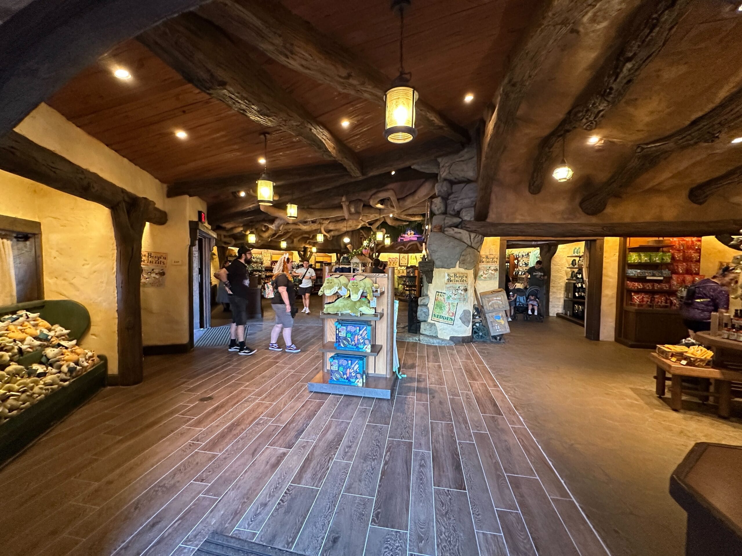 Rustic Critter Co-op gift shop in Magic Kingdom with wooden beams, lanterns, plush toys, and updated flooring—no castle visible.