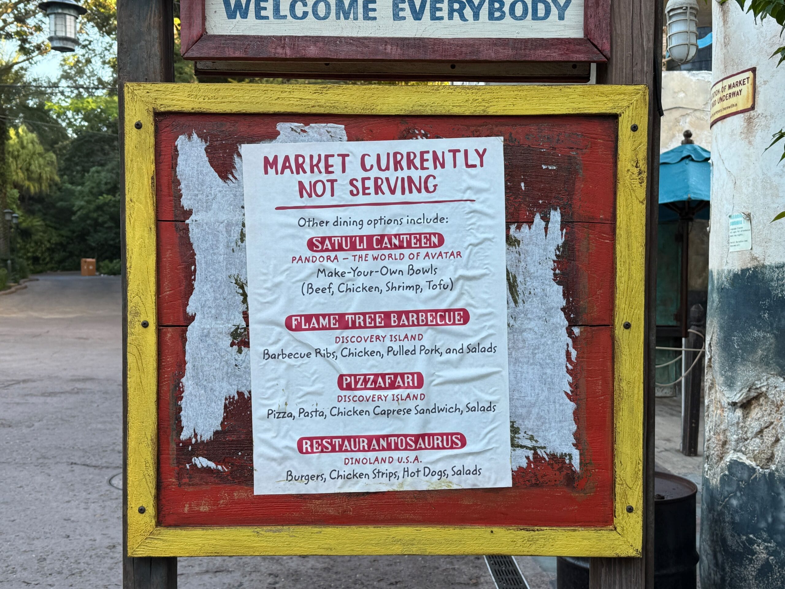 At Disney's Animal Kingdom, a red and yellow outdoor sign details foods unavailable at Trilo-Bites and Dino-Bite Snacks.