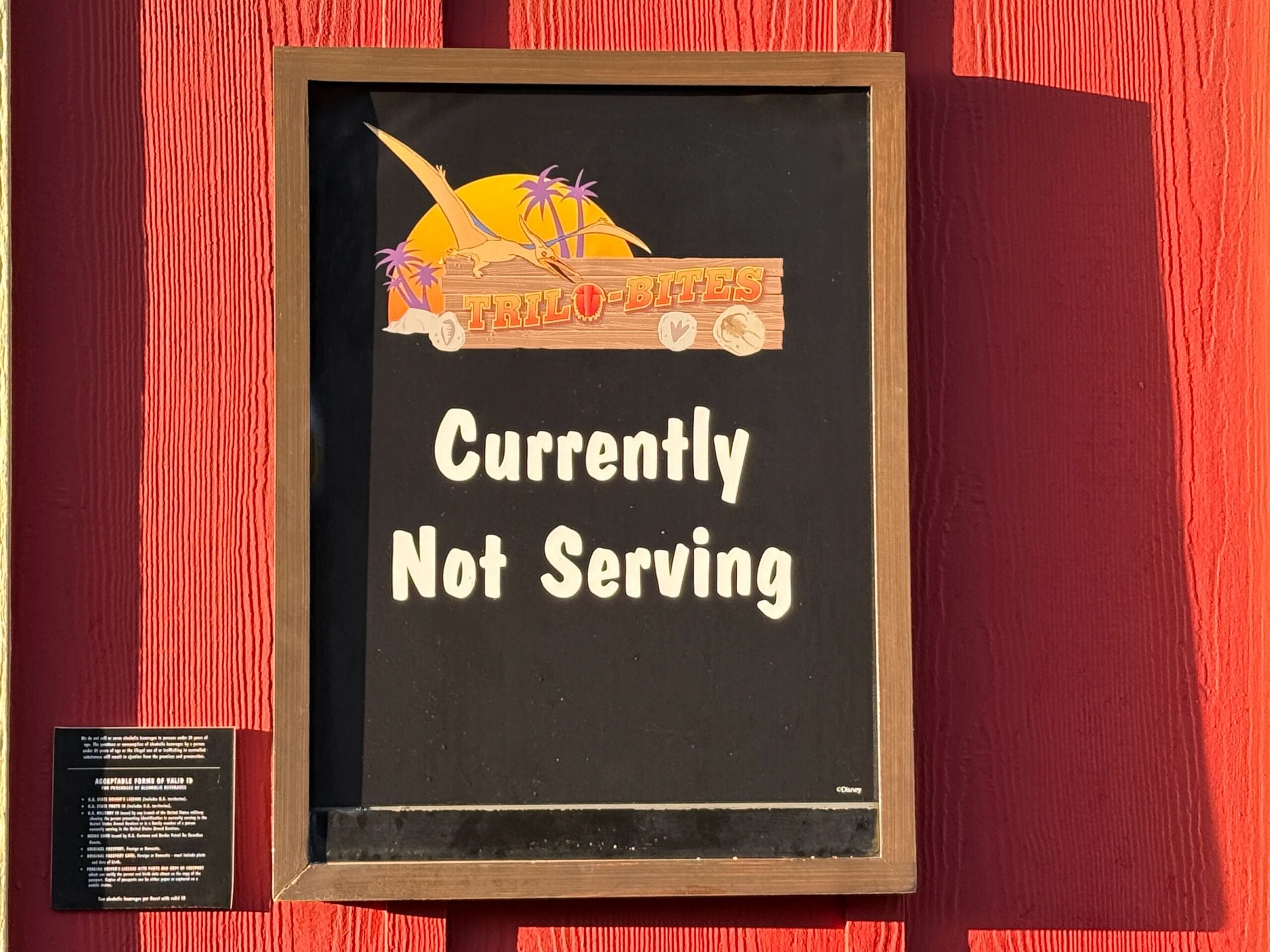 A "Currently Not Serving" sign hangs under a Trilo-Bites logo on a red wooden wall in Disney’s Animal Kingdom, no castle visible.