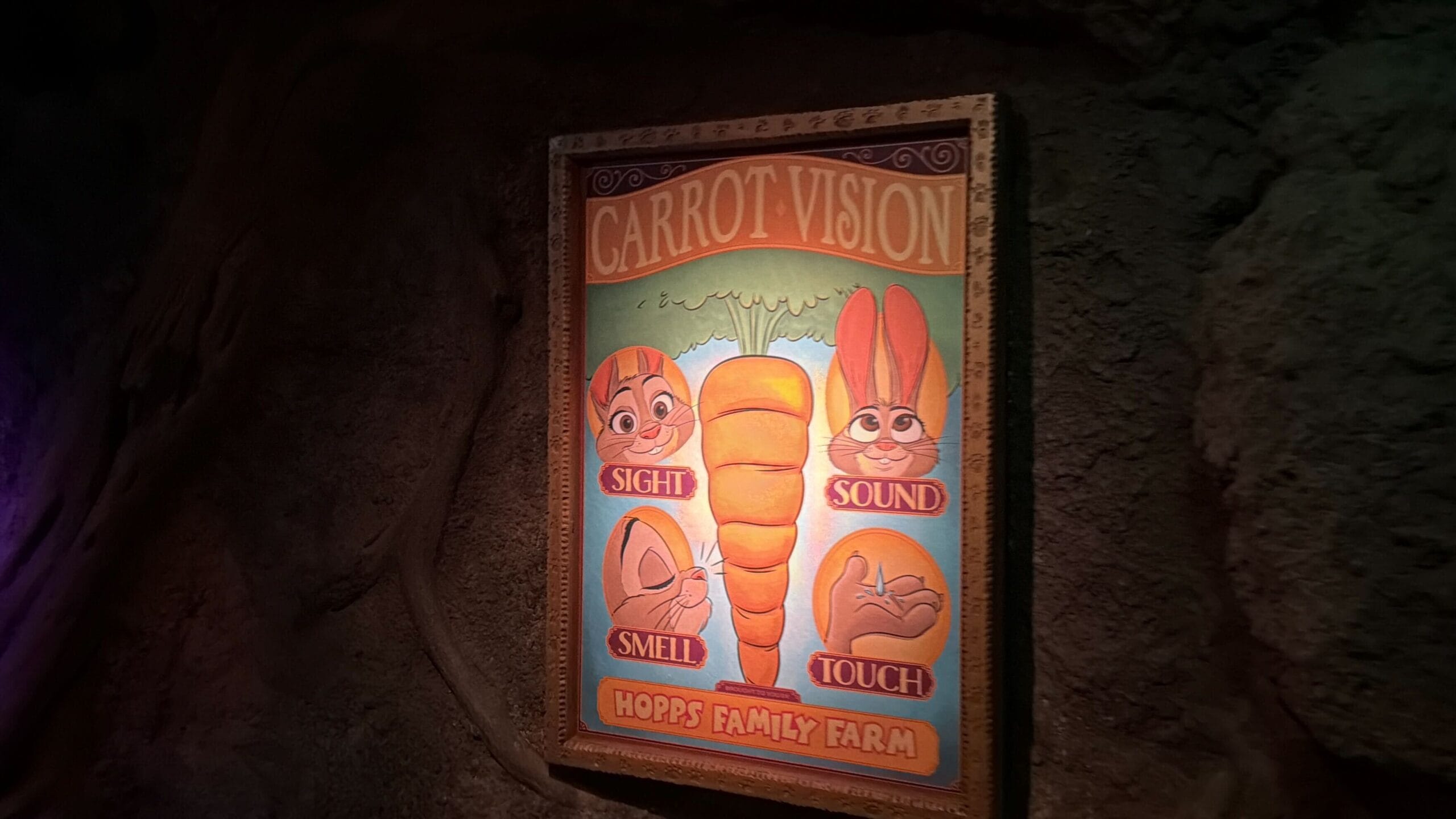 A vibrant "Carrot Vision" sign, like Disney park signage, shows sight, sound, smell, and touch with cartoon bunnies and a carrot.