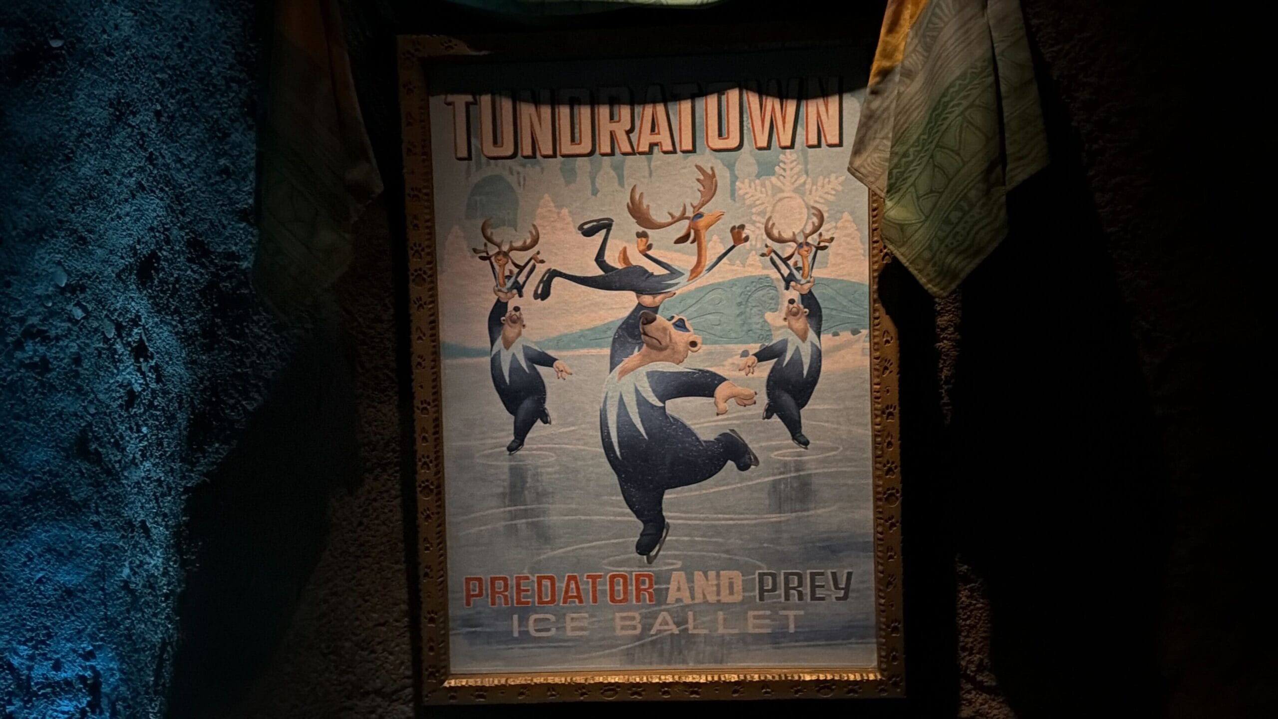 Framed poster shows dancing bears and deer ice skating, titled “Tundratown Predator and Prey Ice Ballet”—no Disney castle shown.