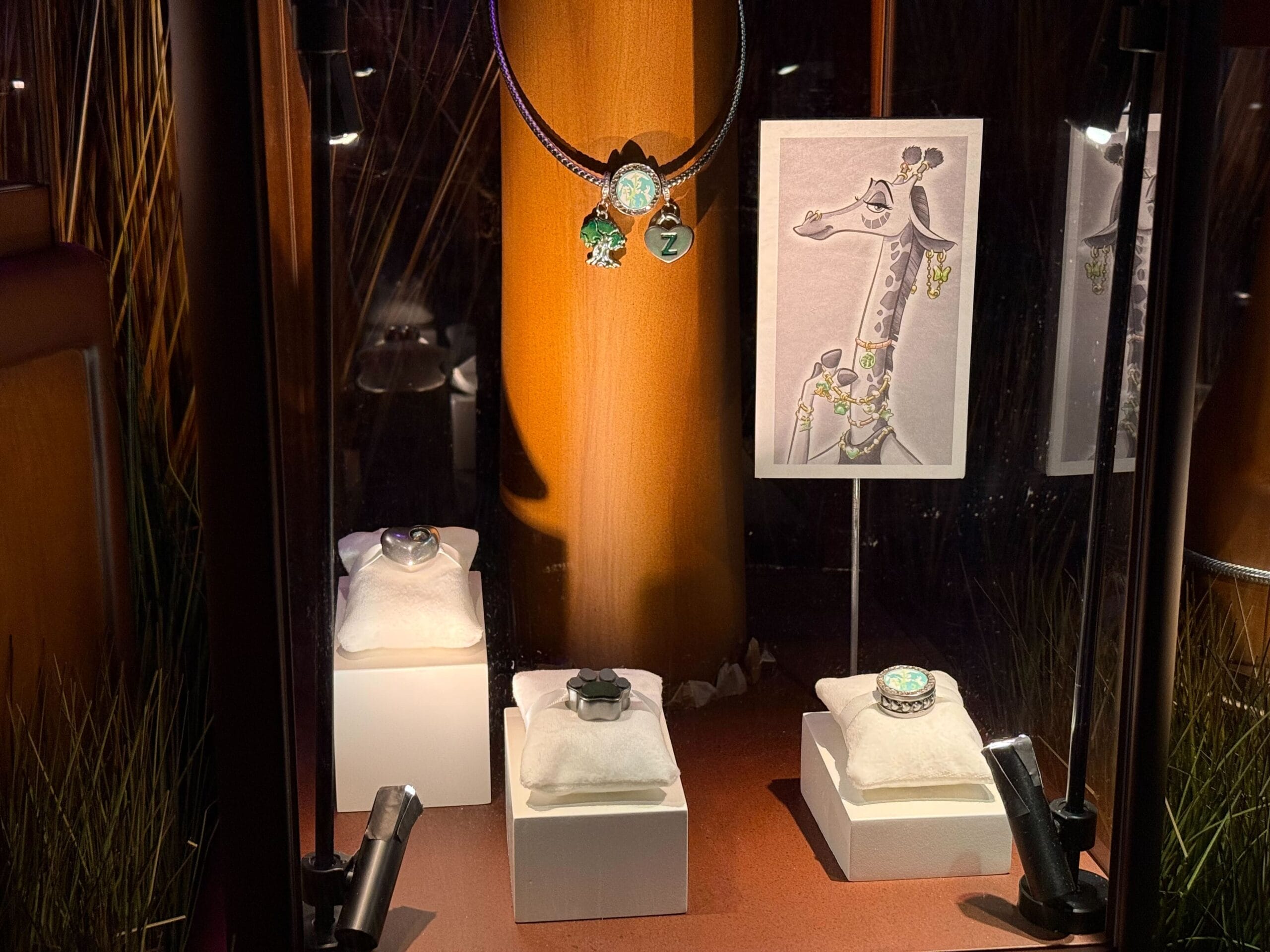 Jewelry display of sparkling rings and pendants, alongside a drawing of a jewelry-adorned giraffe, reminiscent of Disney themes.