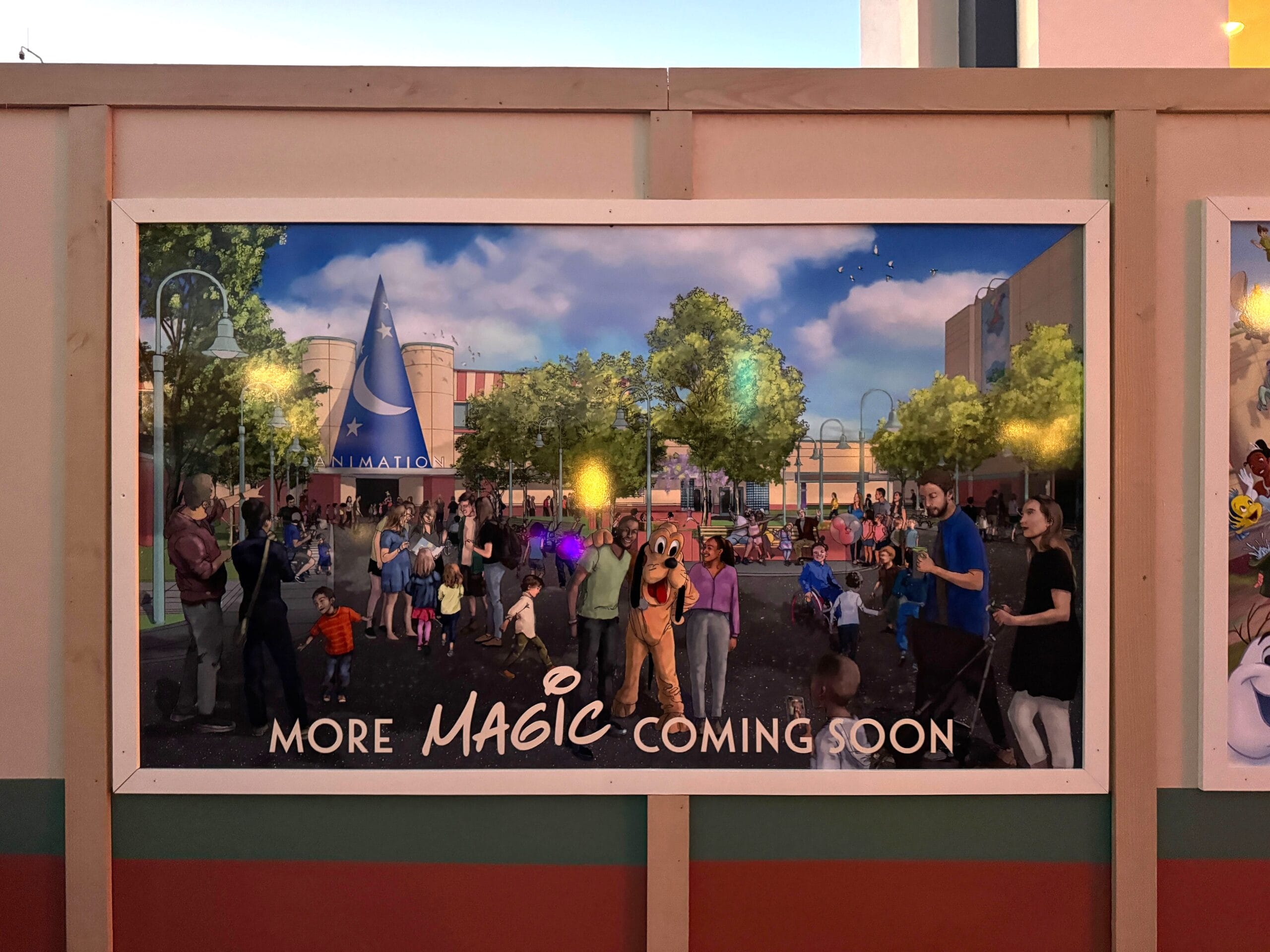 Billboard near Animation building with families and Disney characters, teasing new magic for Disney's Hollywood Studios.