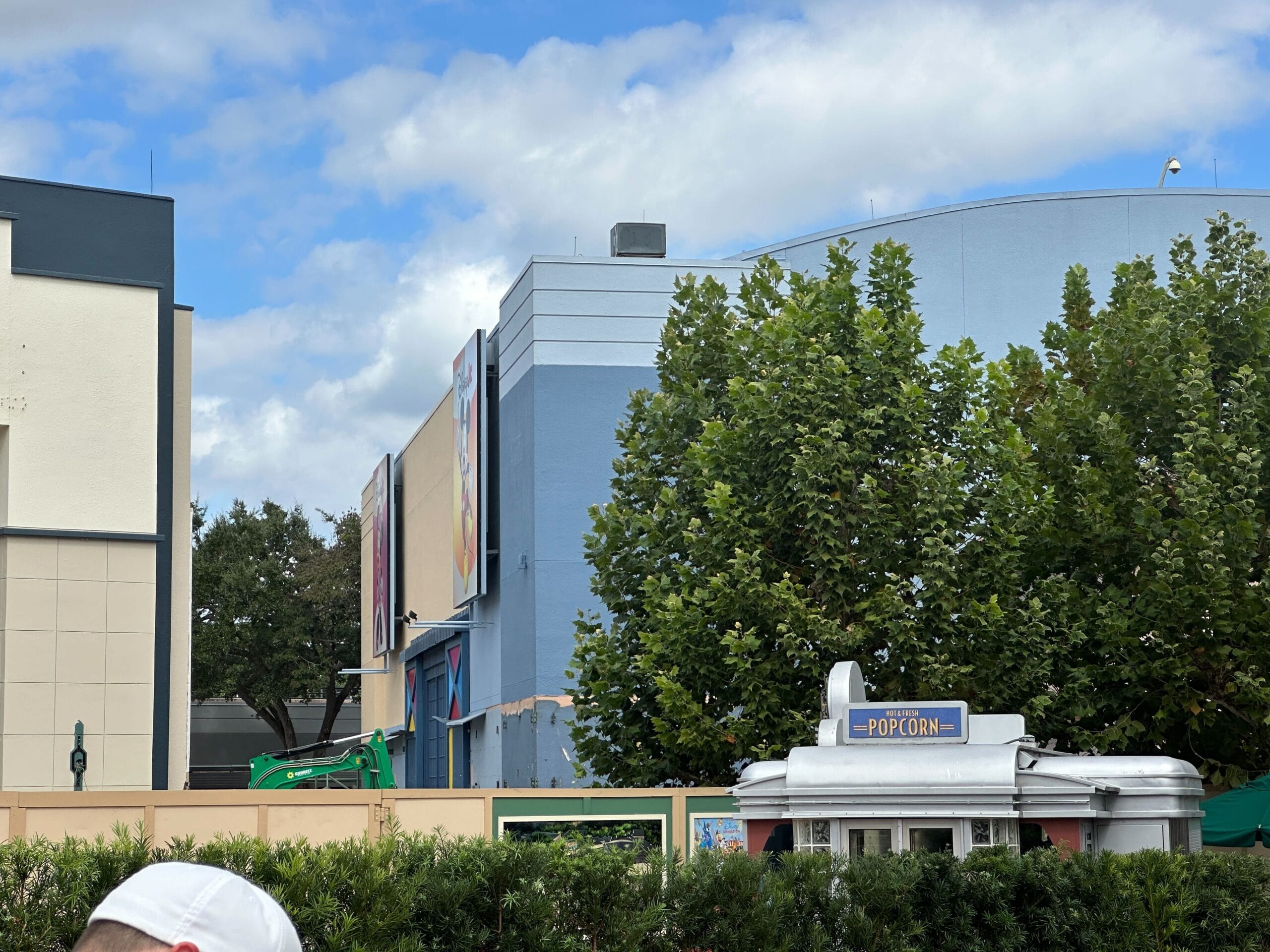 Blue and gray building at Disney’s Hollywood Studios, partly hidden by trees, by a popcorn stand, with demolition nearby—not a castle.