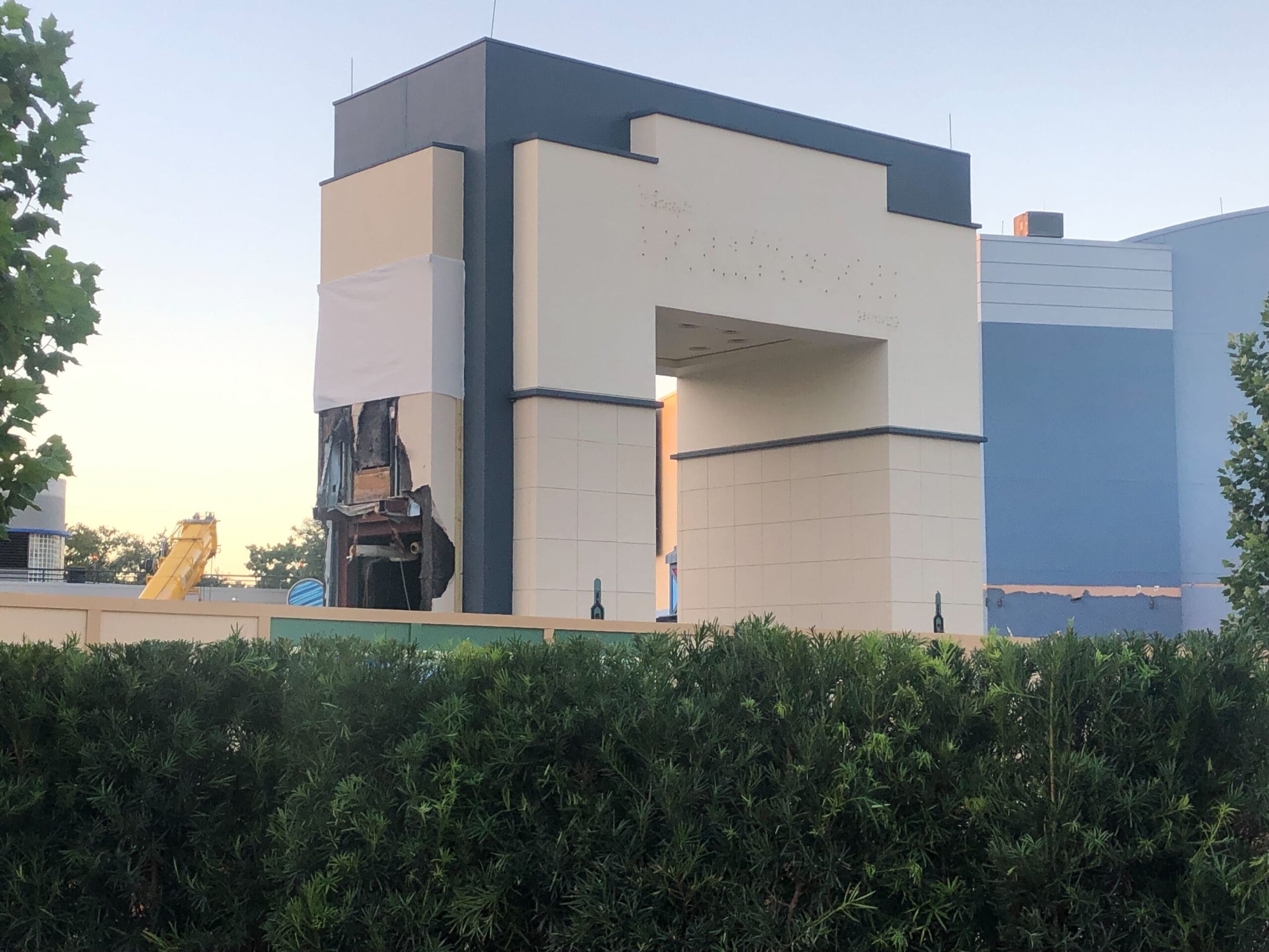Partially demolished building at Animation Courtyard in a Disney park, with exposed walls and construction gear in view.