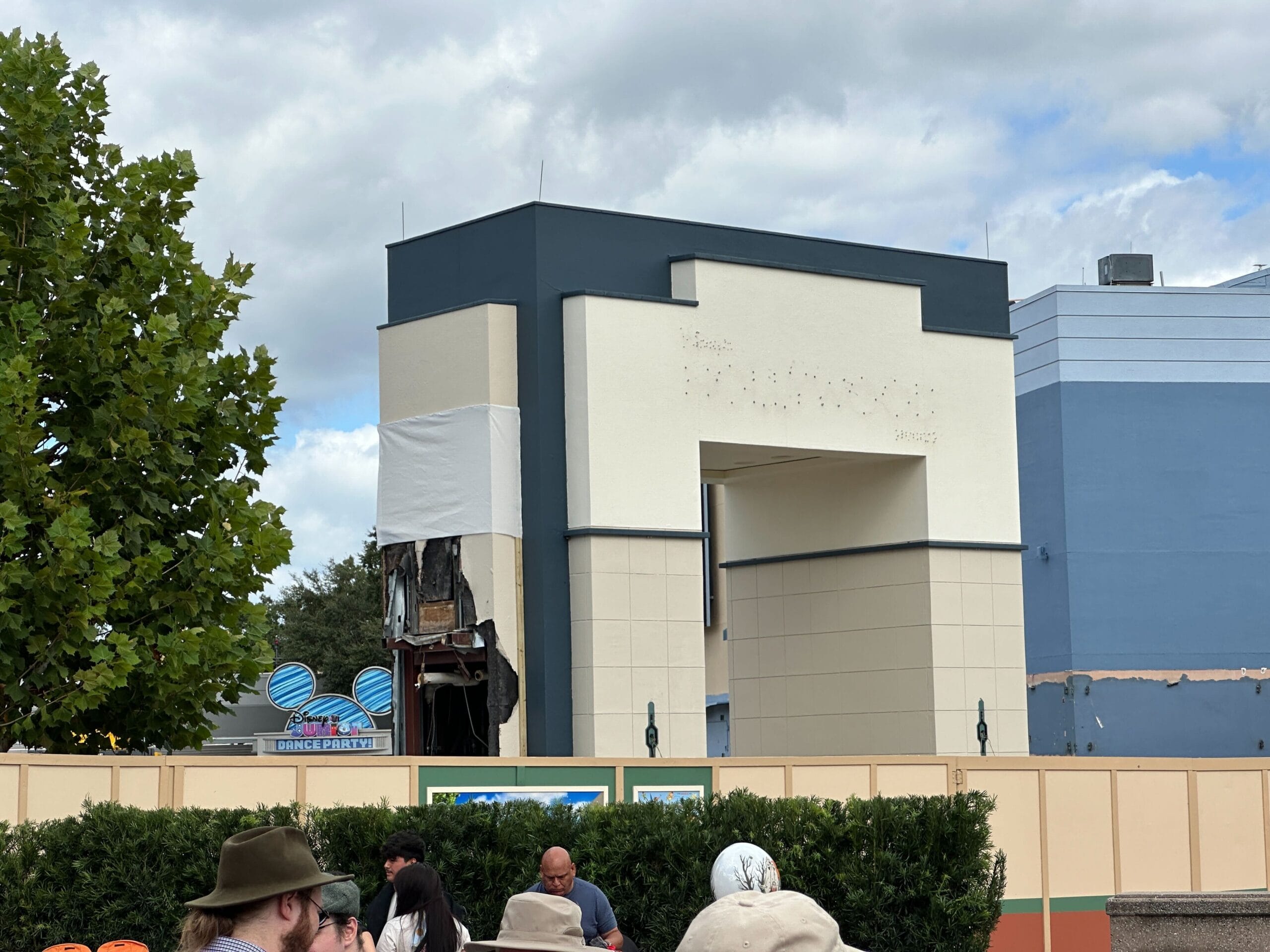 A demolition site at Disney's Hollywood Studios with people in front; cloudy sky above a partially demolished structure, no castle in view.