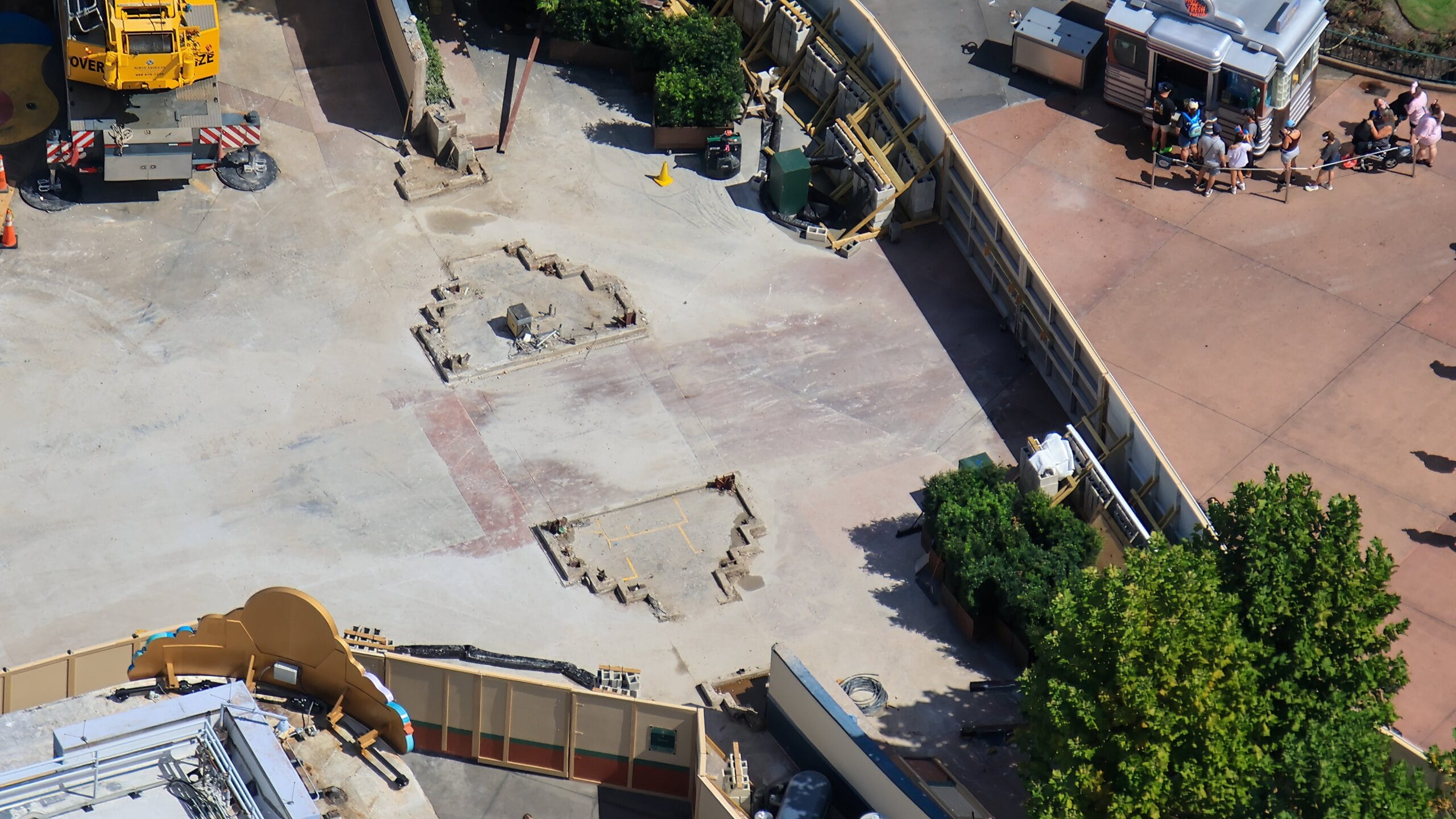 Aerial view of a demolished Disney park site showing Animation Courtyard Arch remains, supplies, fencing, and greenery—no castle in sight.